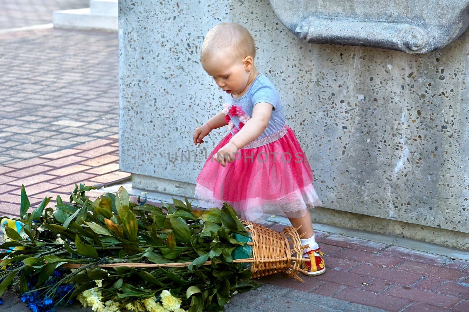 Girl child traveler knocked over a basket of flowers, discovering the world by jovani68