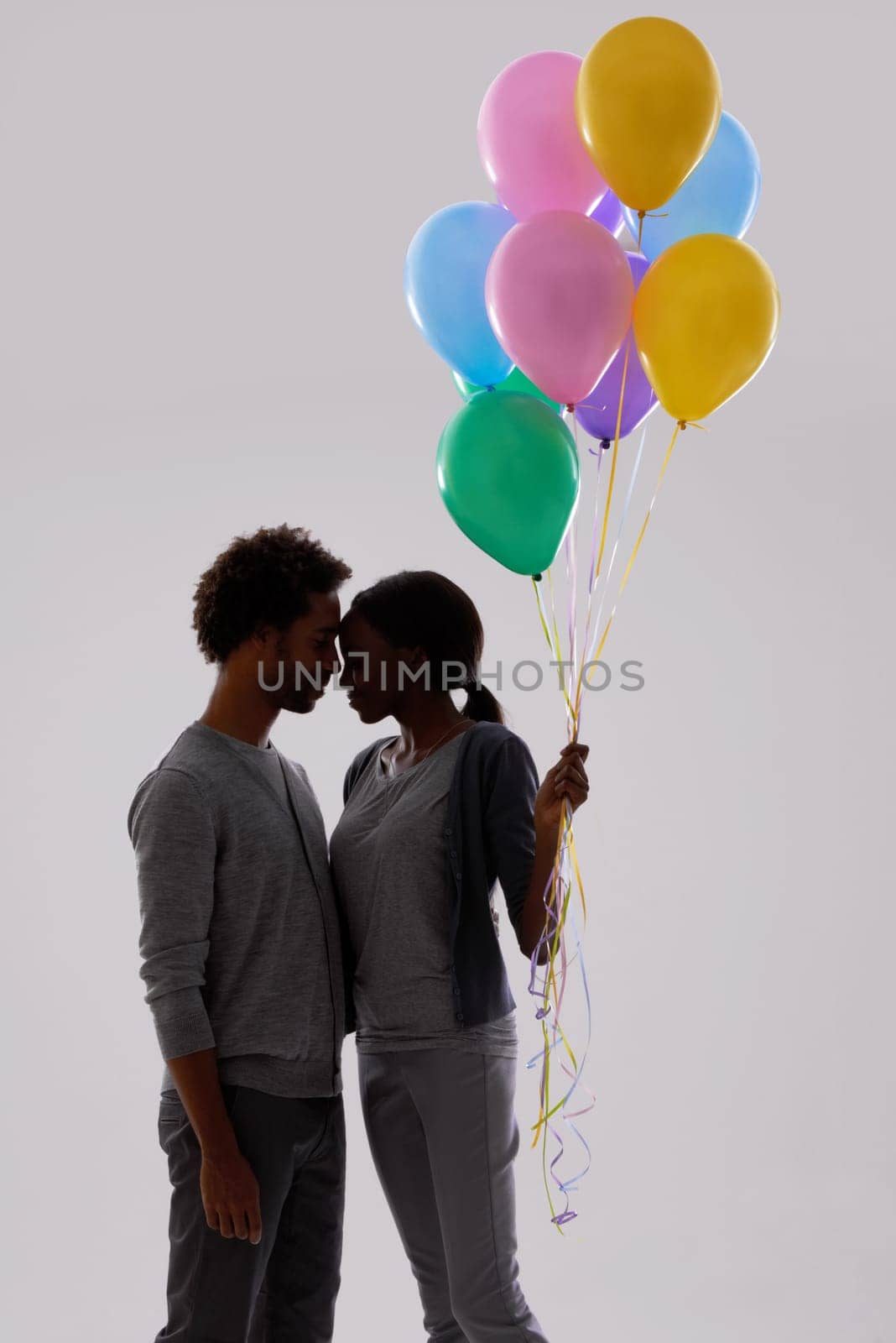 Couple, silhouette and love with party balloons for celebration, event or romance on a gray studio background. Man and woman with colorful blowups of helium for date or anniversary on mockup space by YuriArcurs