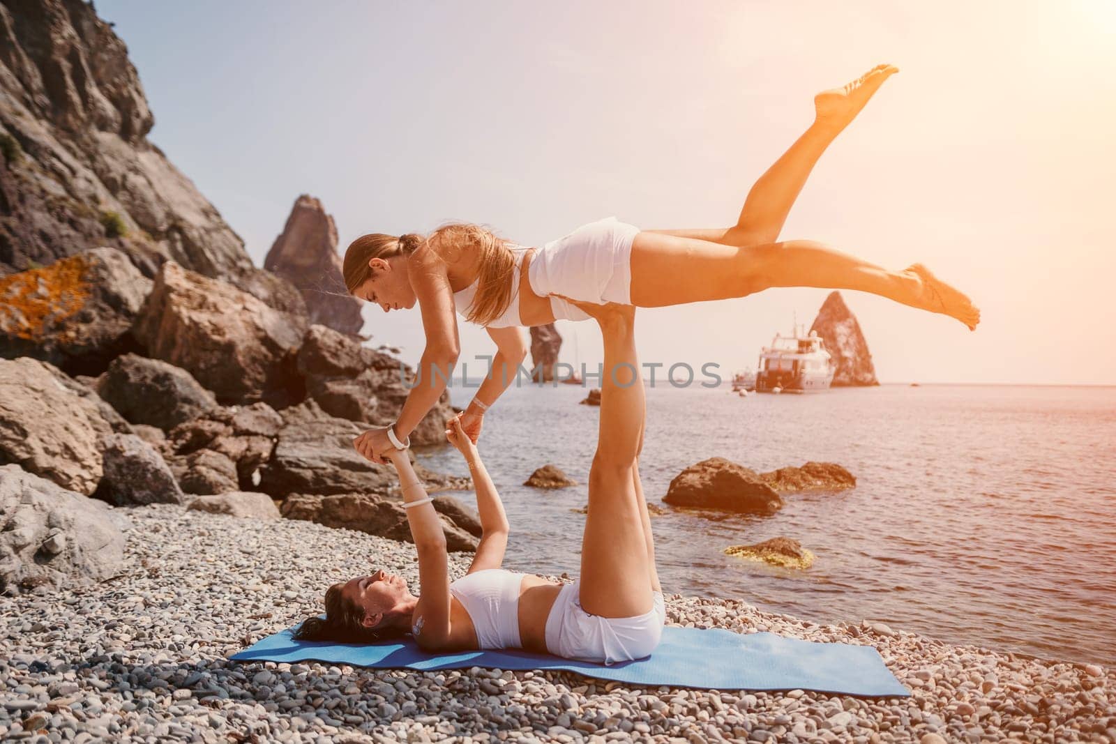 Woman sea yoga. Back view of free calm happy satisfied woman with long hair standing on top rock with yoga position against of sky by the sea. Healthy lifestyle outdoors in nature, fitness concept.