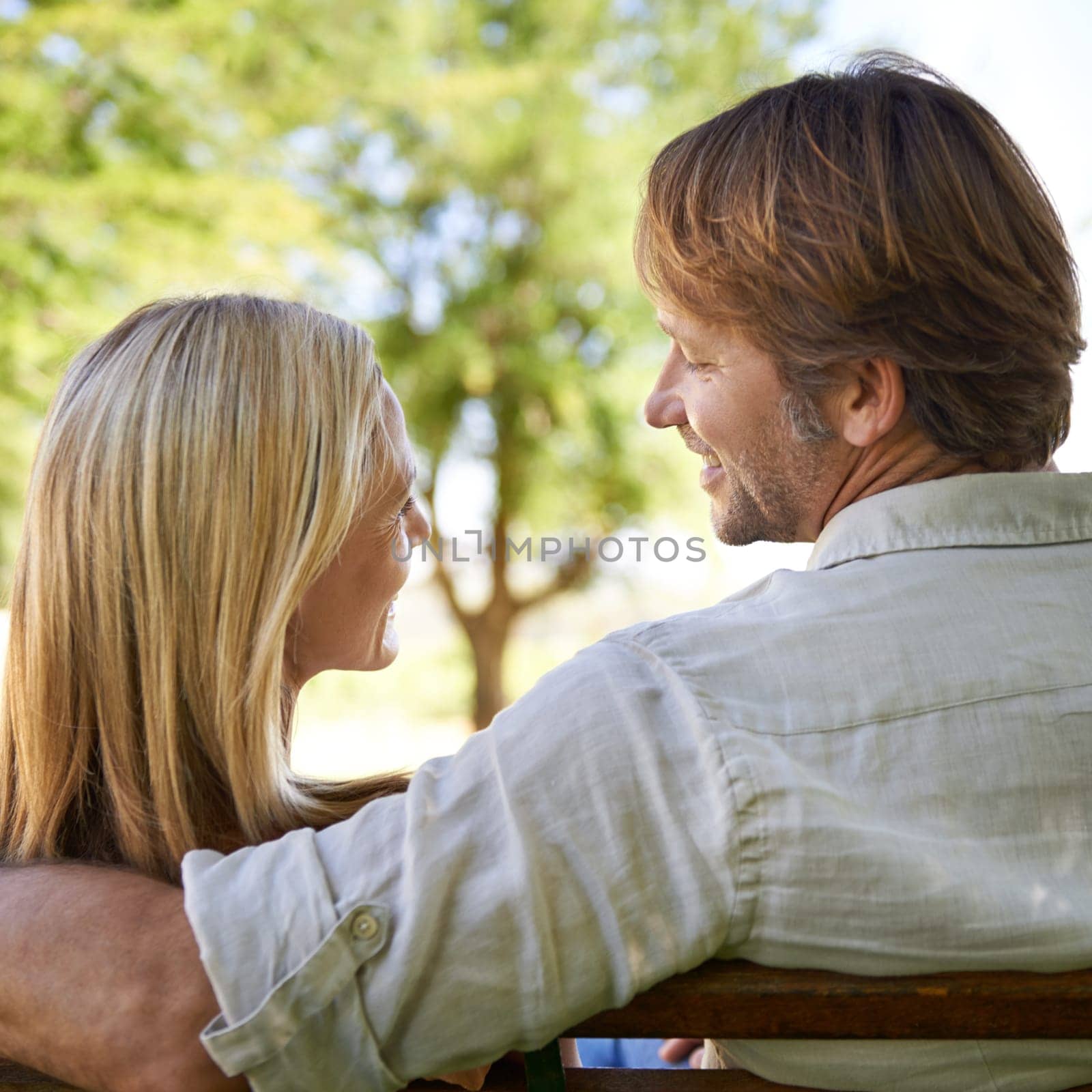 Couple, back and bonding on bench, love and connection in relationship or security in outdoors. Mature people, laugh and date in nature or romance in garden, travel and vacation or support on holiday.