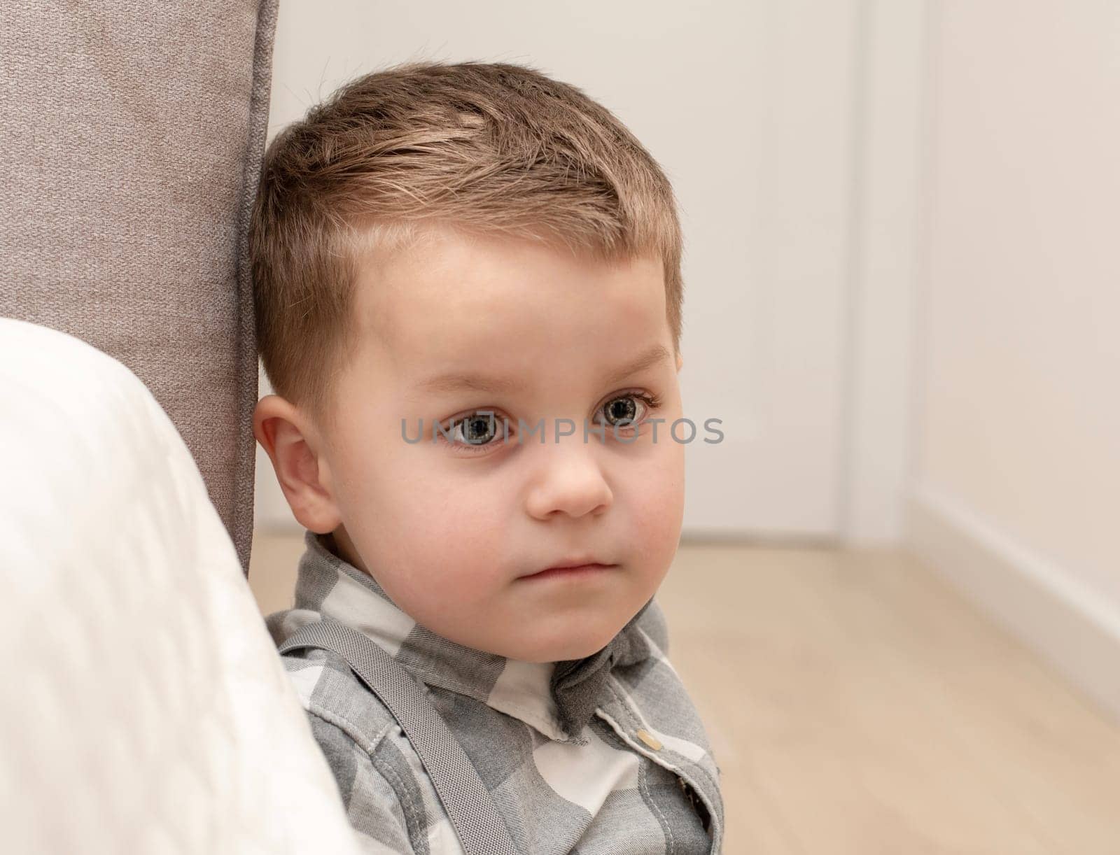 Emotions of calm, thoughtfulness on the child s face. A small handsome boy of 4 years old in a shirt with a bow tie shows a mime with a facial expression. Close-up. portrait