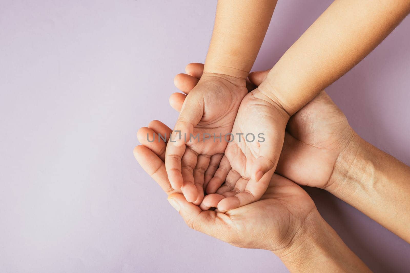 Parents and kid hold empty hands top view isolated on color background. Embracing Family Day symbolizing togetherness support and heritage. by Sorapop