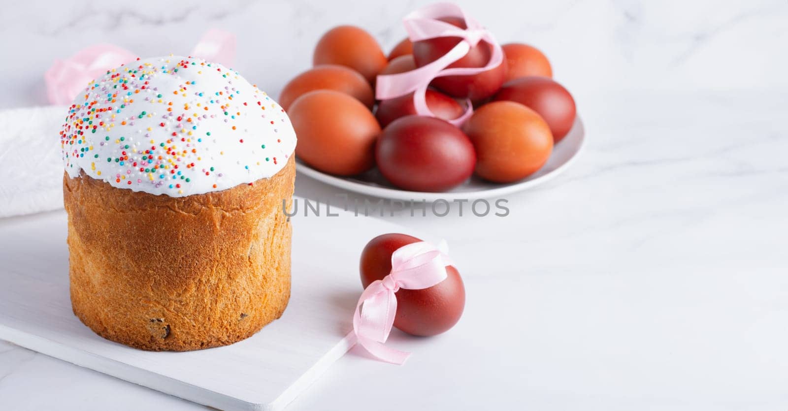 Delicious Easter cakes and eggs on light background, with copy space for text.