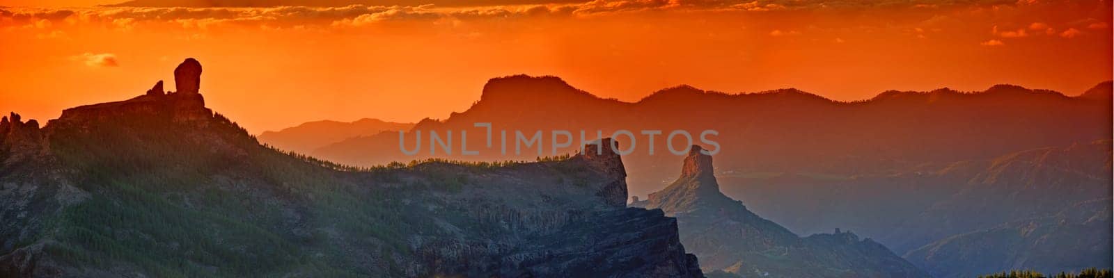 Landscape, sunset and panorama view of mountains, Gran Canaria Island with nature skyline and environment. Orange sky, horizon and natural background with travel location or destination in Spain by YuriArcurs