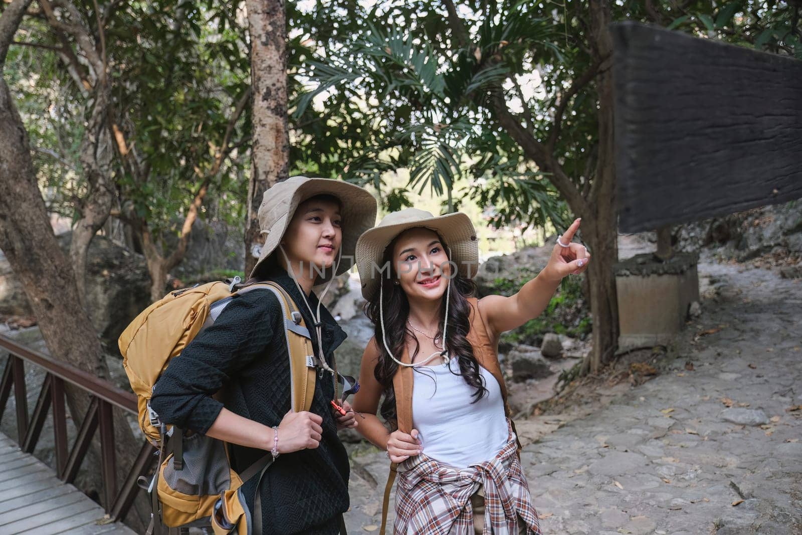 Asian couple hiking in nature Studying the hiking route following the signs..