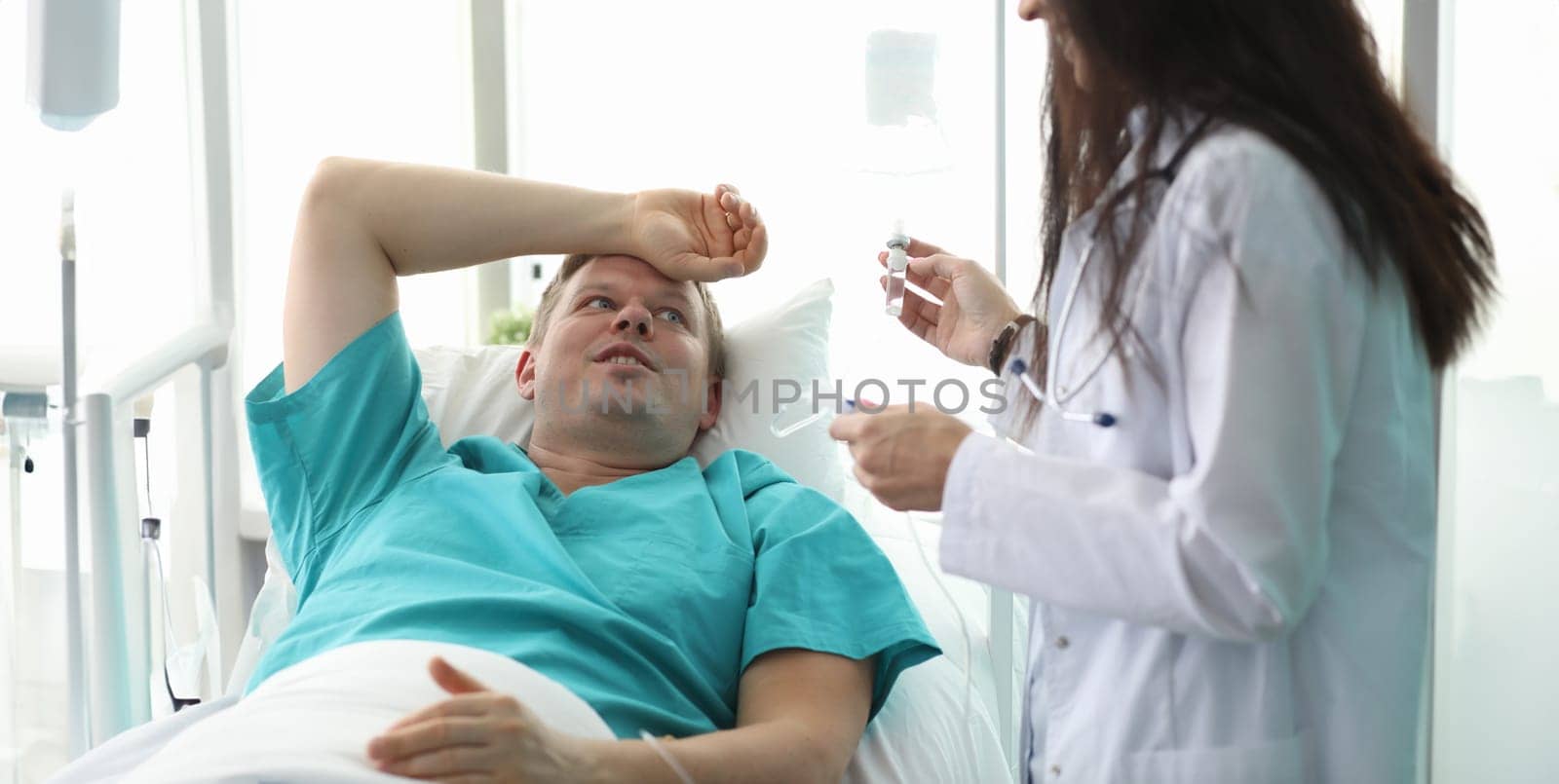 Female doctor preparing dropper for male patient. Observation patients by clinic doctors. Development individual recommendations for drug therapy. In-depth diagnosis condition body