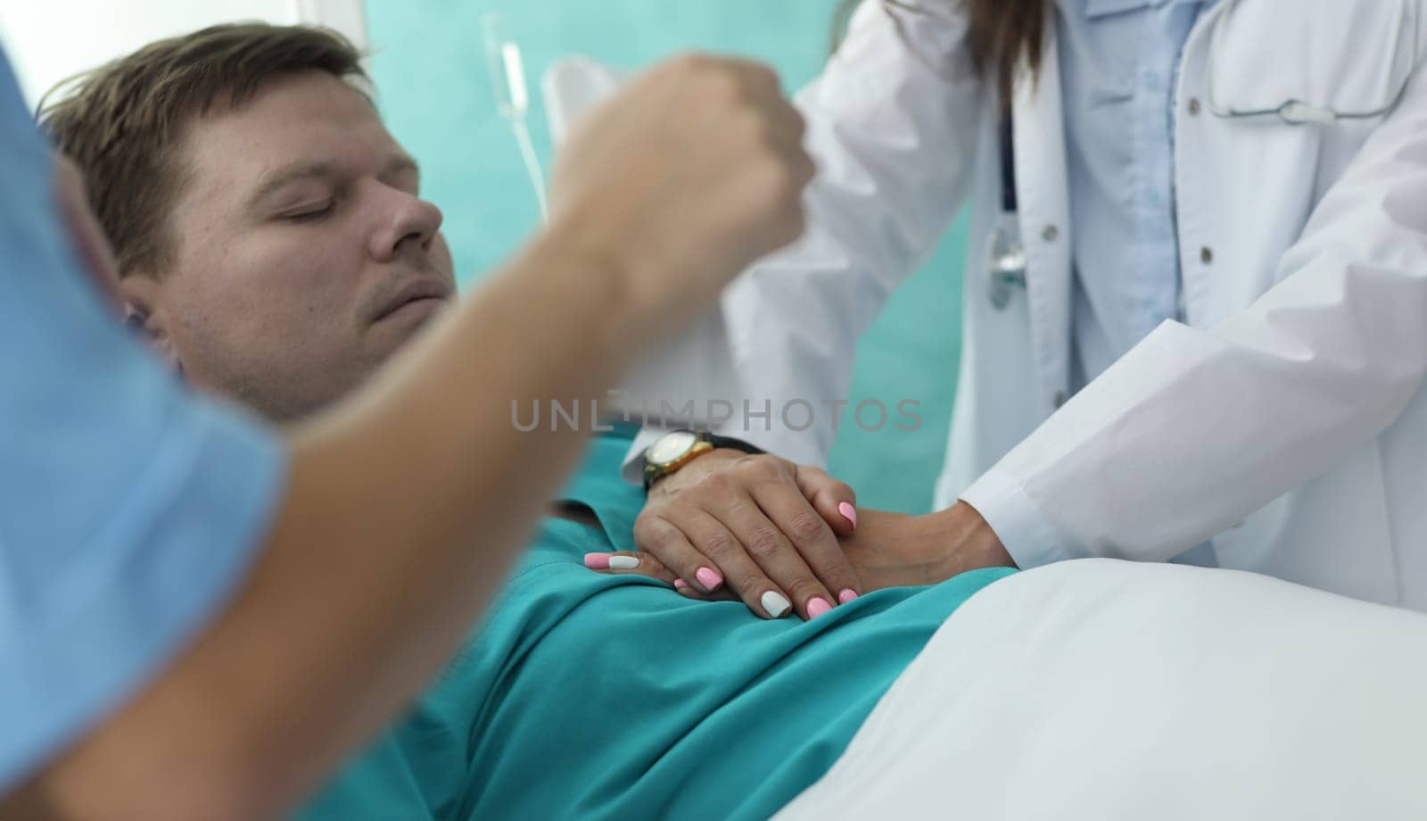 Hands nurse doing heart massage to man in clinic by kuprevich