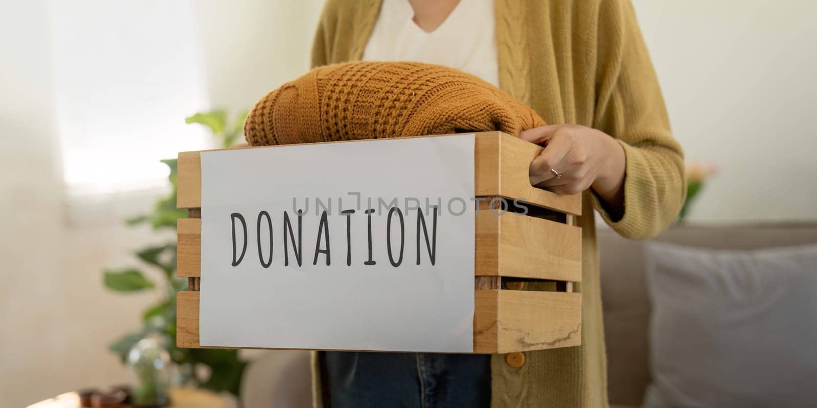 Donation, asian young woman sitting pack object at home, putting on stuff into donate box with second hand clothes, charity helping and needy people. Reuse recycle by nateemee