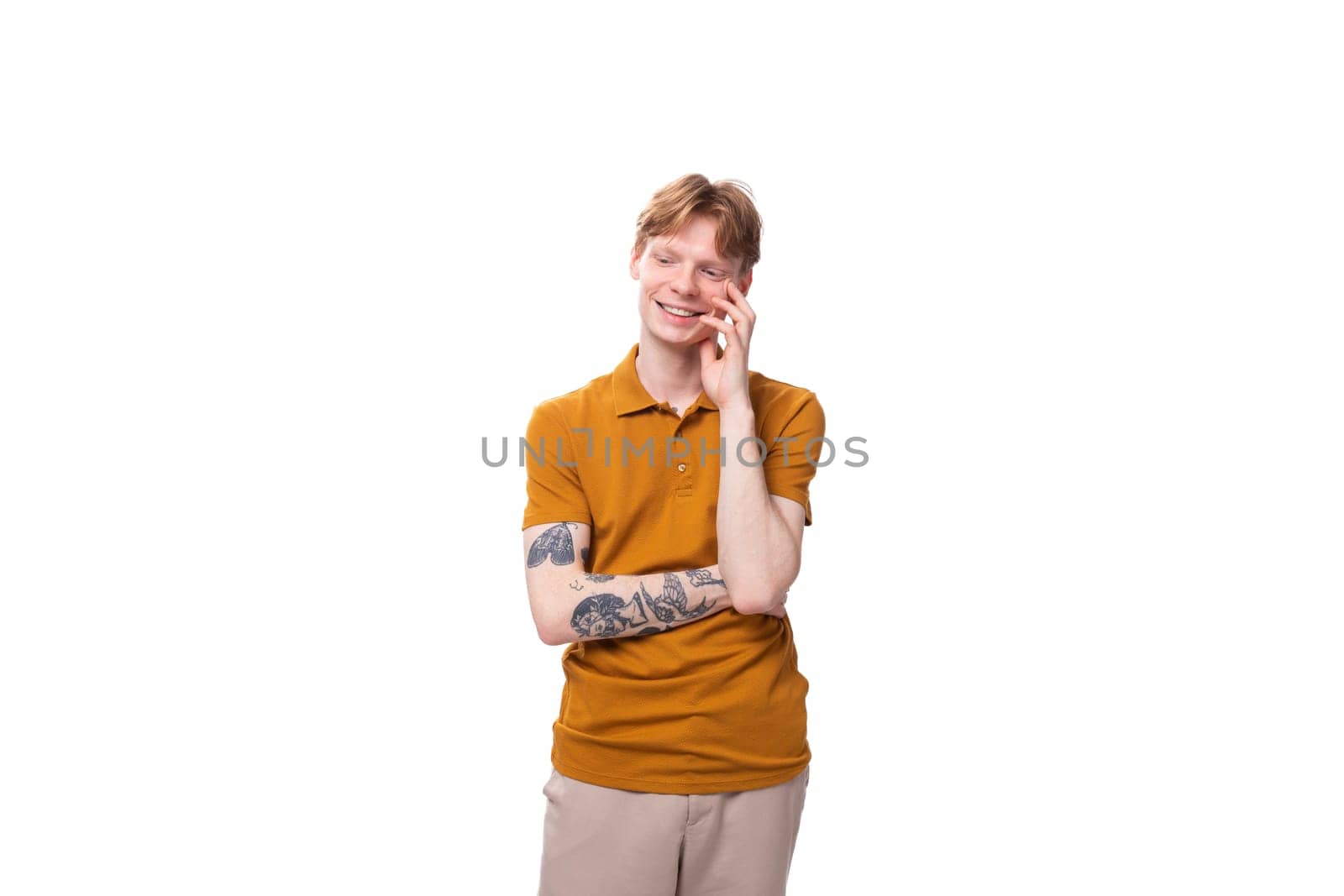 young fashionable student man with short red hair dressed in a yellow t-shirt is actively gesturing.