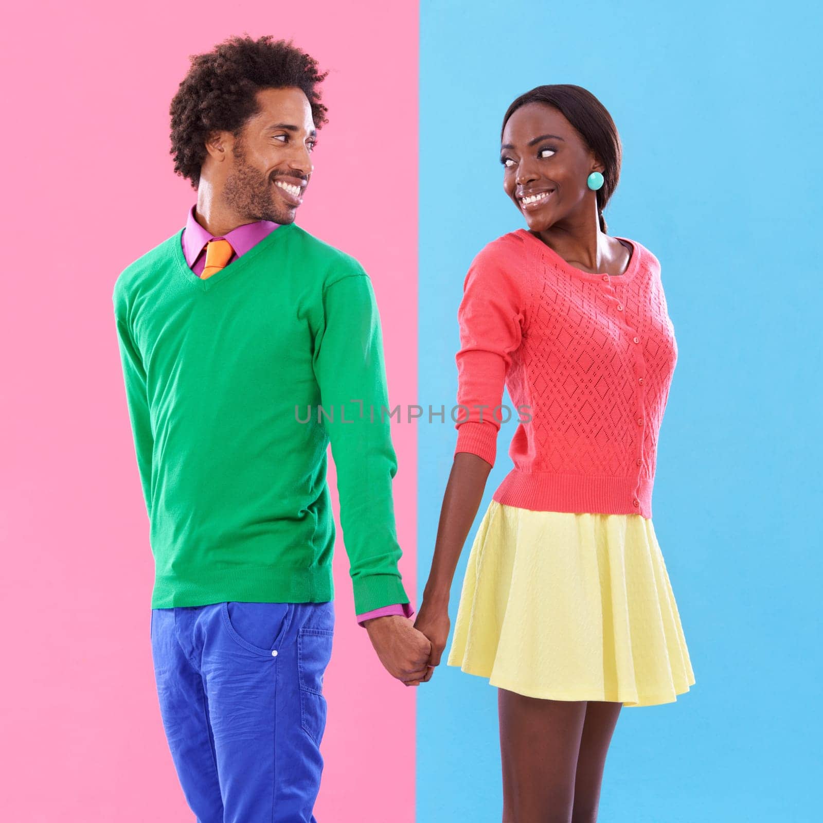 Fashion, smile and black couple holding hands in studio with colorful, trendy and stylish outfit. Happy, love and young African man and woman with edgy, classy and retro style by background. by YuriArcurs