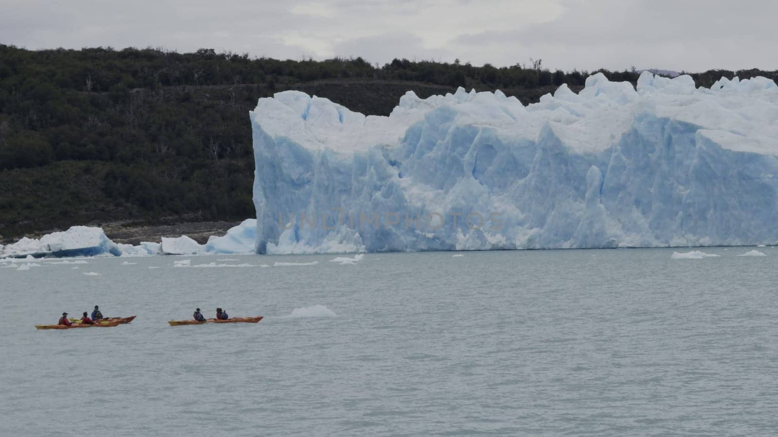 Kayakers approach Perito Moreno Glacier's ice walls in slow-mo.