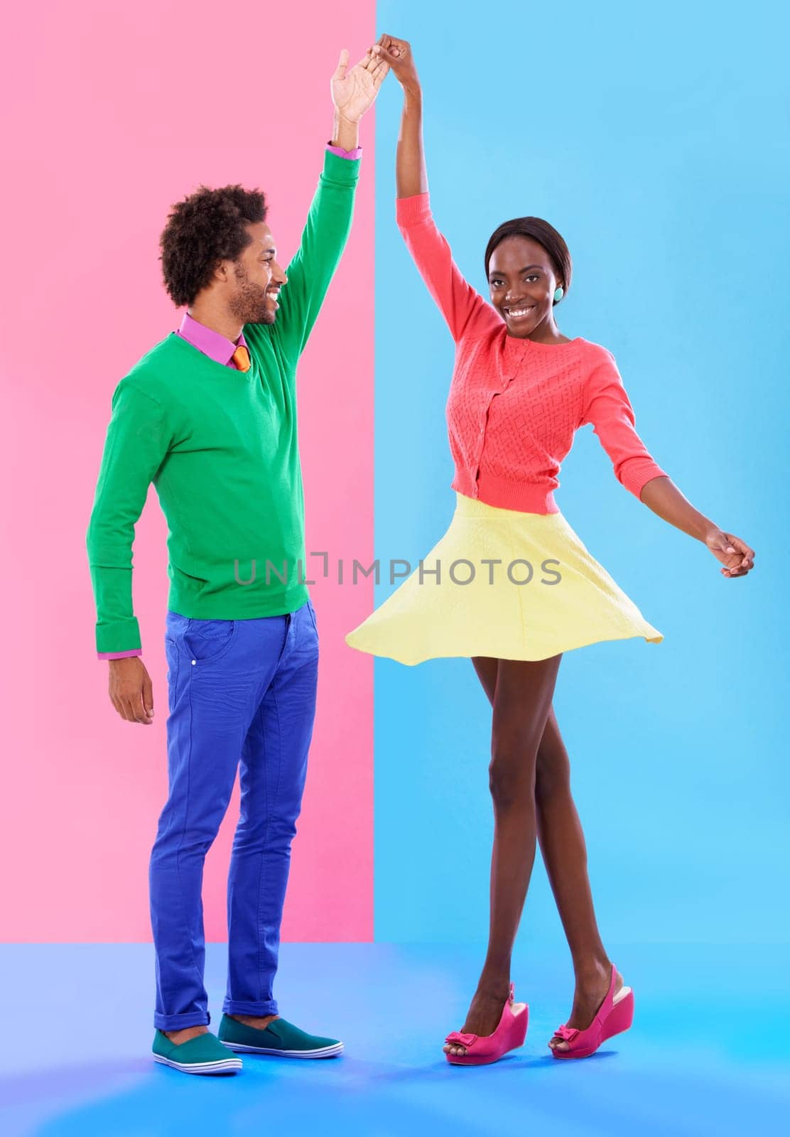 Happy, dance and couple in studio with fashion and holding hands, spinning and creative portrait. African, woman and man together with colorful retro style, unique clothes or moving with support by YuriArcurs