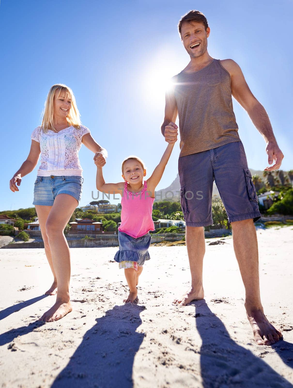 Family, child and smile on beach with walk for sunshine, holiday and summer vacation in Costa Rica. Nature, parents and holding hands with daughter for happiness, travel and seaside fun on sand.