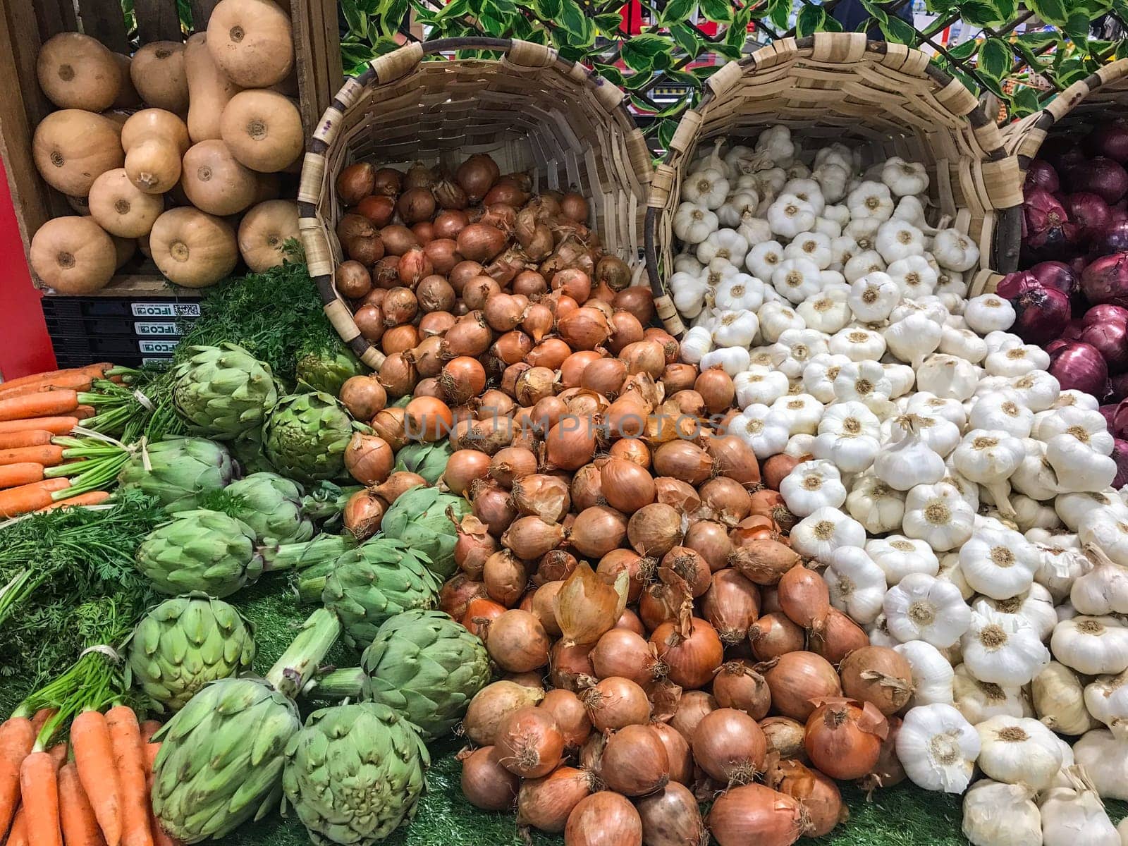 Garlic, white onions, red onions and artichokes sold in wicker baskets in supermarkets, High quality photo