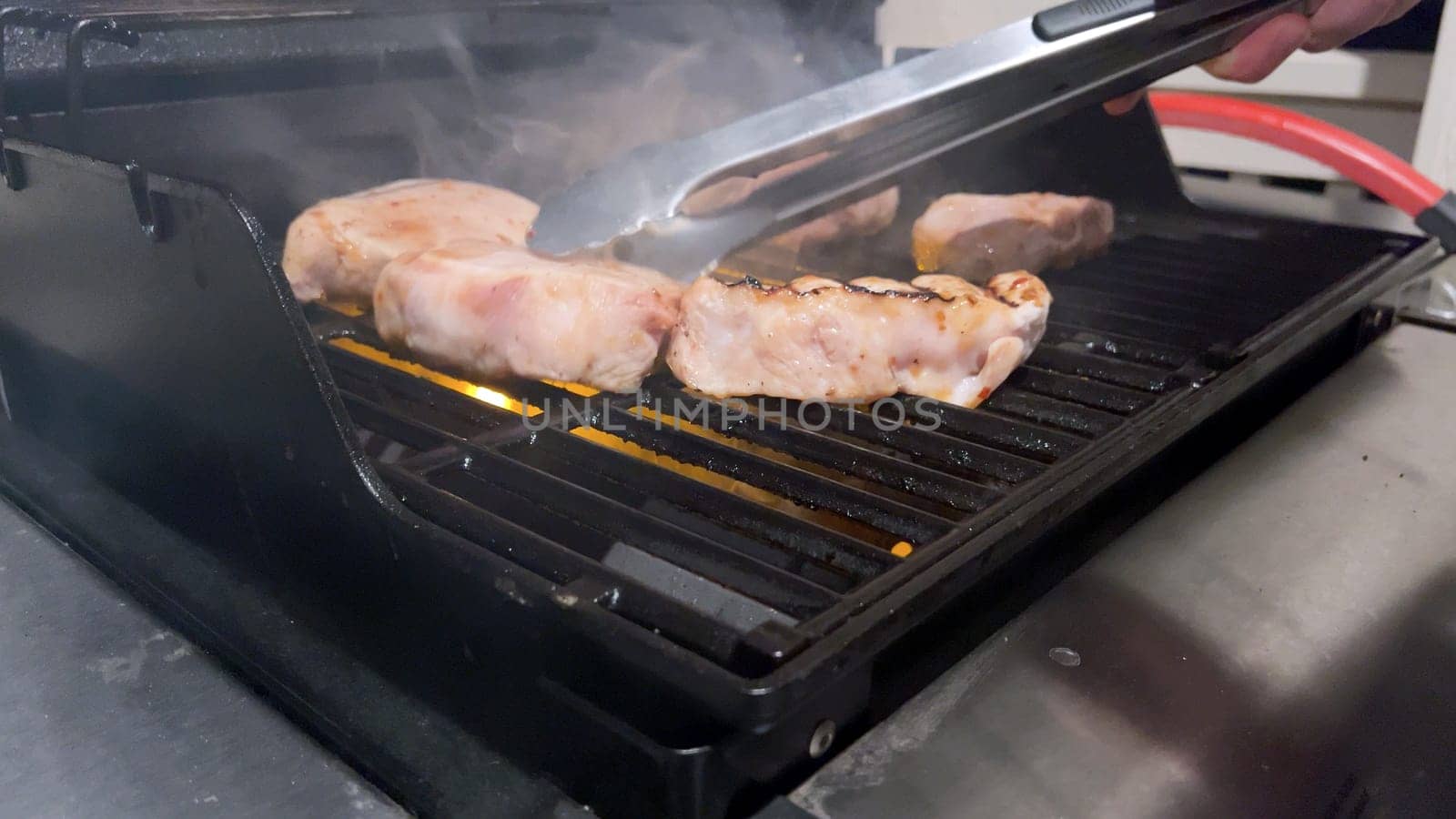 Perfectly Seasoned Pork Chops Sizzling on an Outdoor Gas Grill by arinahabich