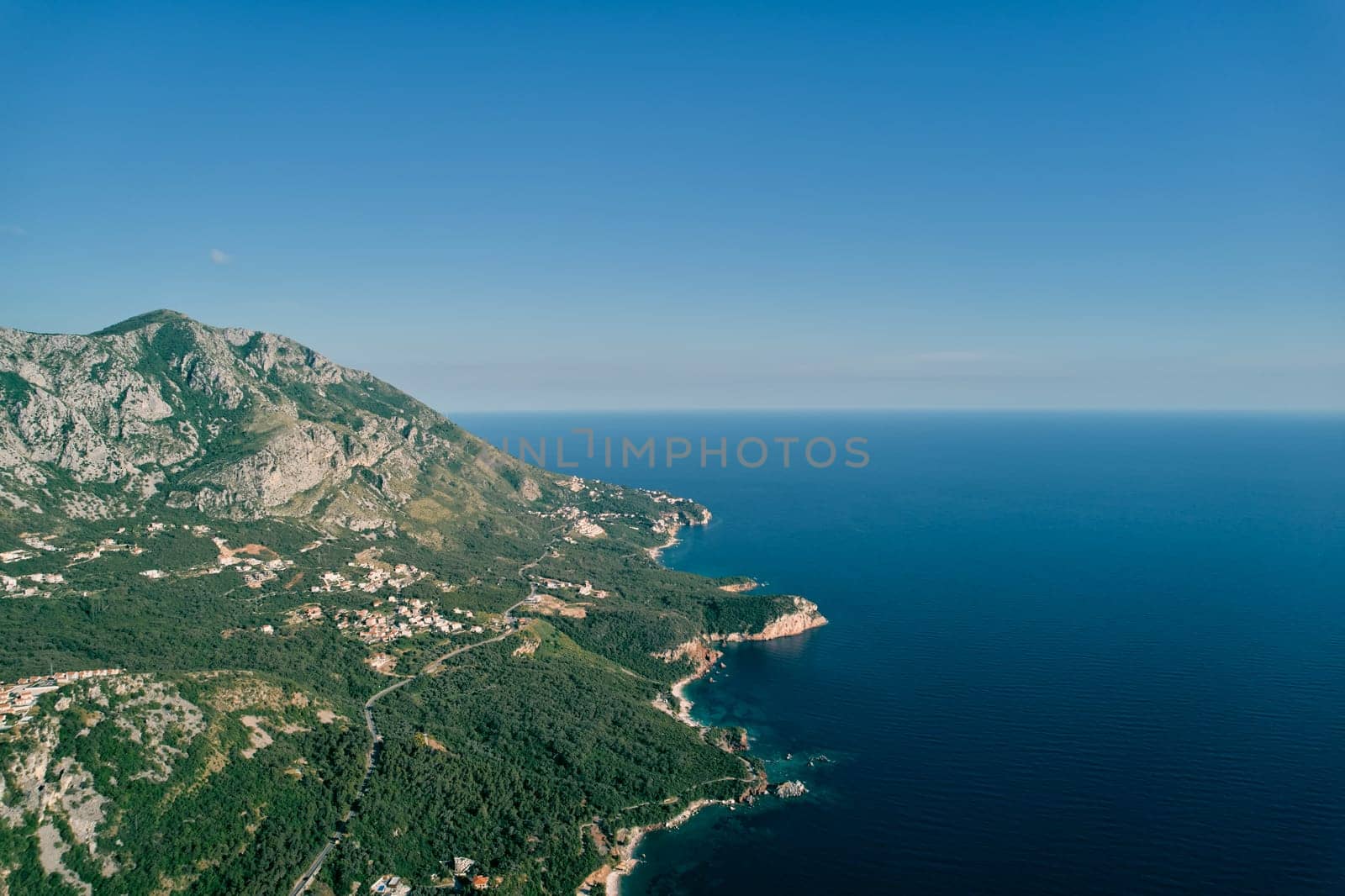 Mountain highway on a slope above a blue bay. Montenegro. Drone by Nadtochiy