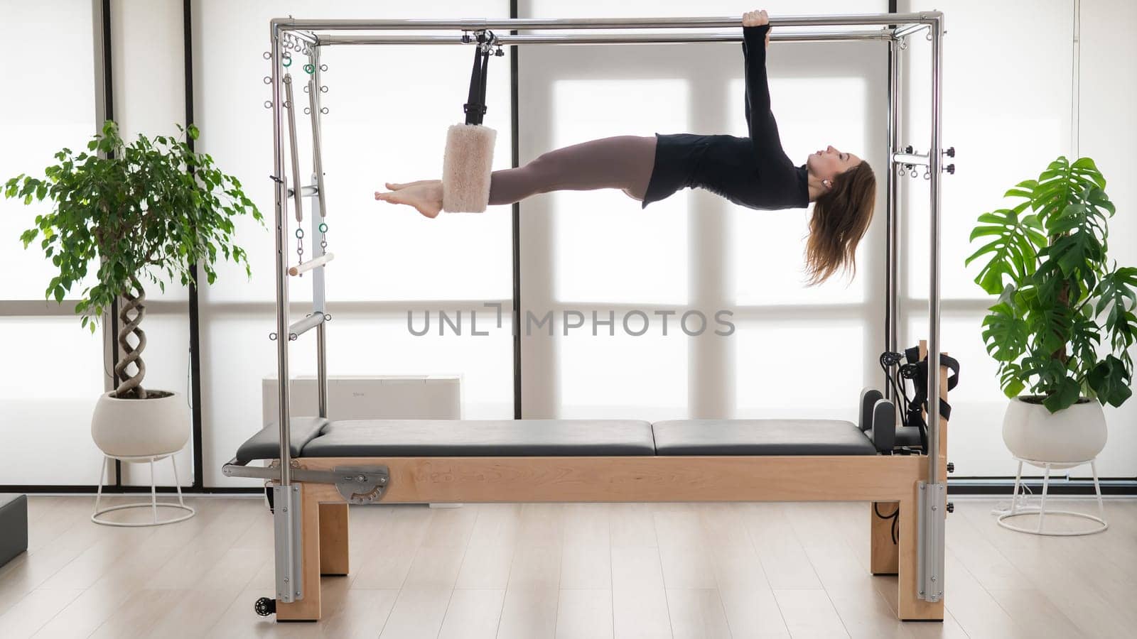 Caucasian woman doing aerial exercises on a reformer machine