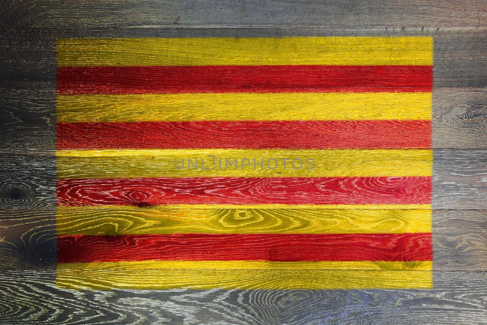 A Catalonia flag on rustic old wood surface background red yellow