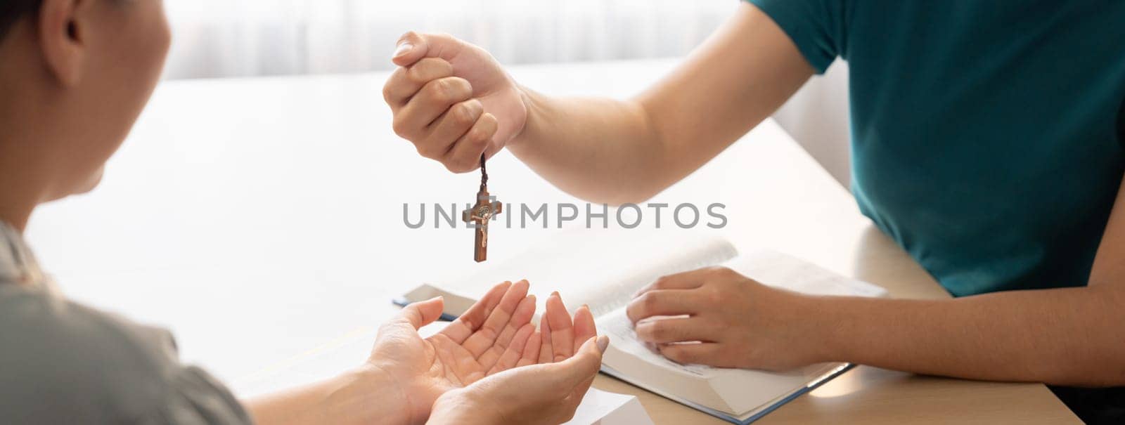 Close-up women prayer deliver wooden cross to young believer. Burgeoning. by biancoblue