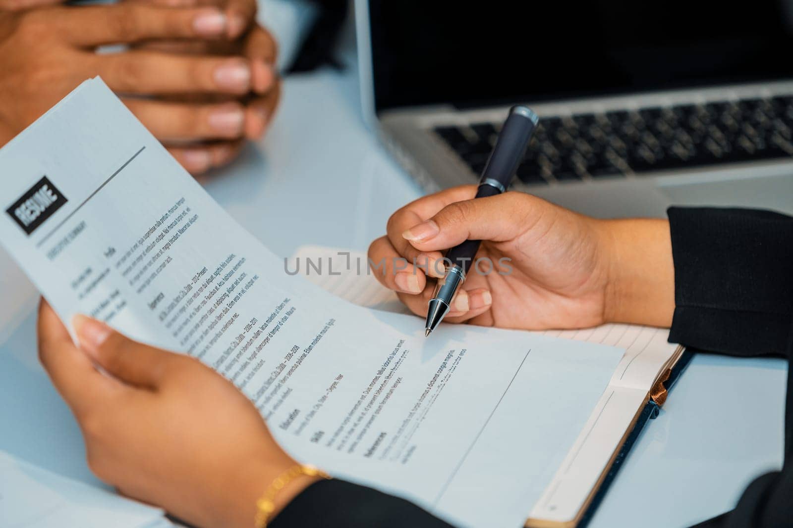 Human resources department manager reads CV resume document of an employee candidate at interview room. Job application, recruit and labor hiring concept. uds