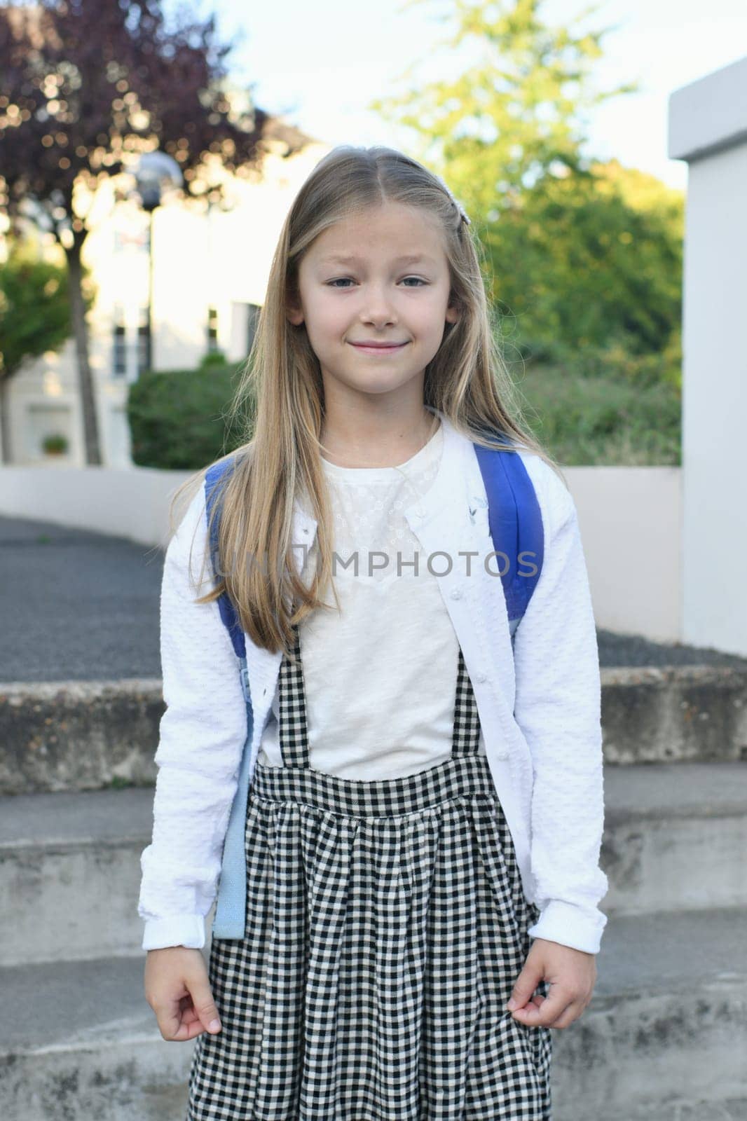 A girl in a school uniform and a backpack back to school