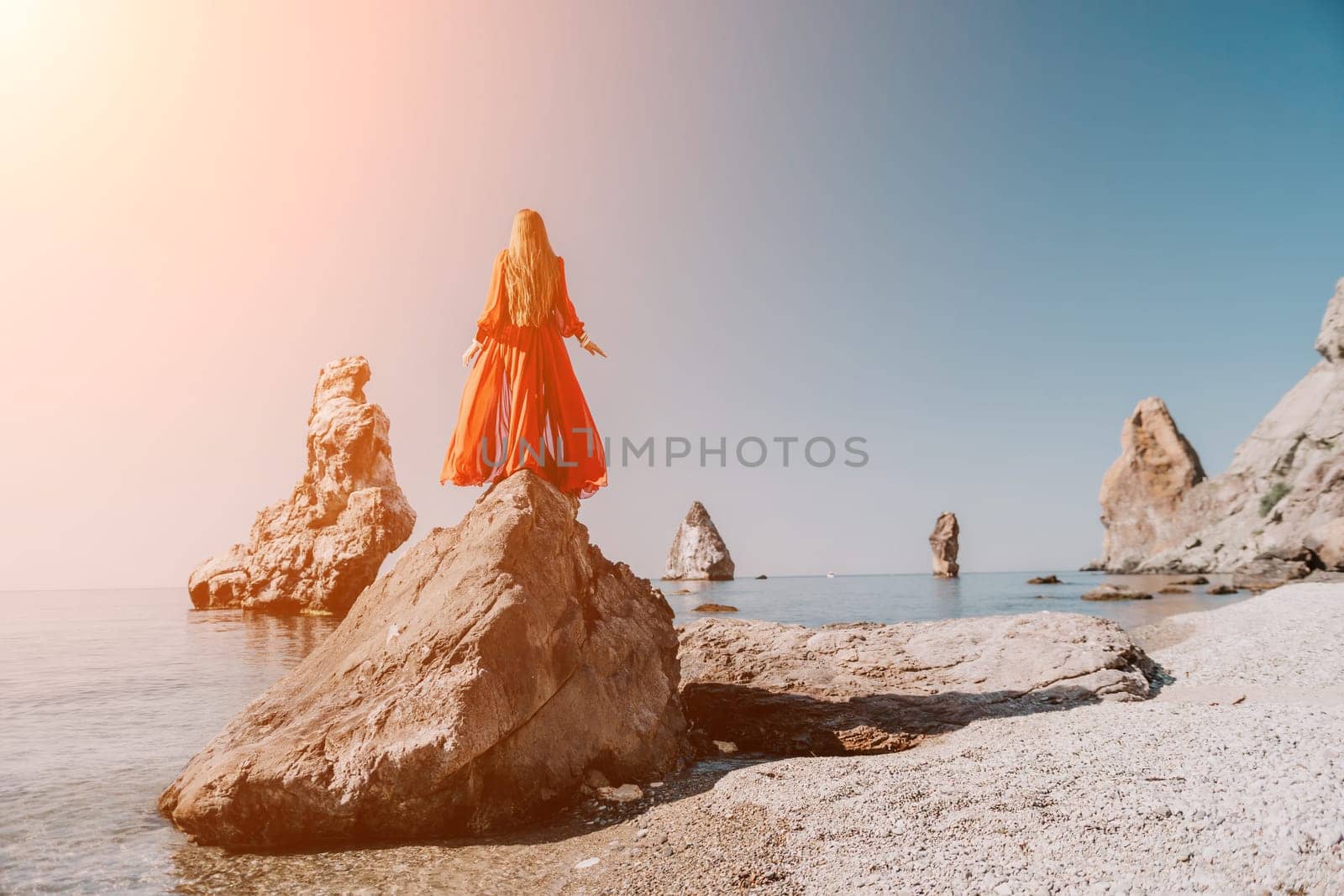 Woman travel sea. Happy tourist taking picture outdoors for memories. Woman traveler looks at the edge of the cliff on the sea bay of mountains, sharing travel adventure journey.