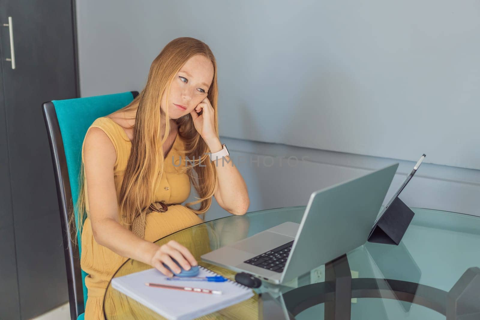 Beautiful pregnant woman working on laptop. Young businesswoman working in her office.