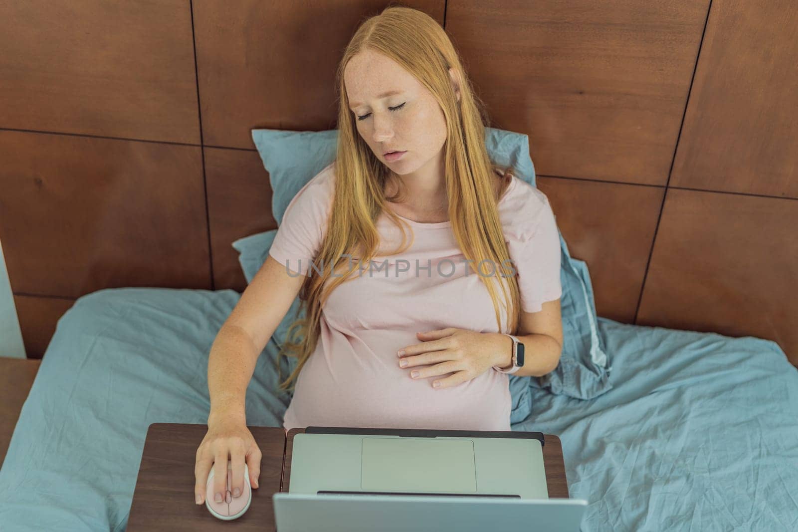 Weary pregnant woman, tired of working from home, navigates the challenges of balancing professional tasks with pregnancy demands.