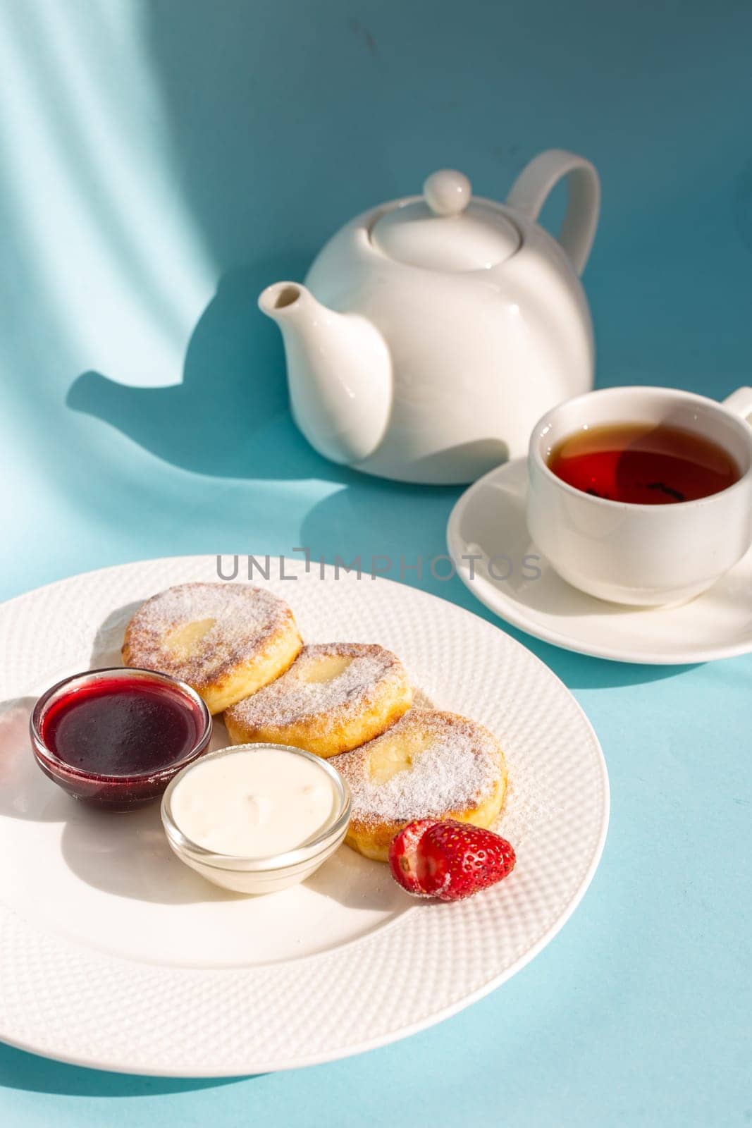 Enjoy a wholesome breakfast with fluffy cottage cheese pancakes topped with jam, fresh strawberries, and a dollop of sour cream. Energize your day with this delicious and nutritious meal.