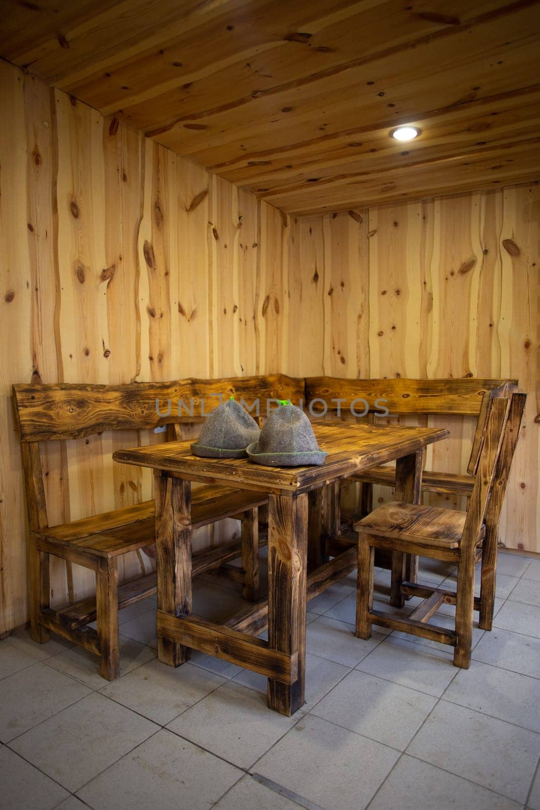 Rustic wooden table and benches in a cozy cabin with warm lighting by Pukhovskiy