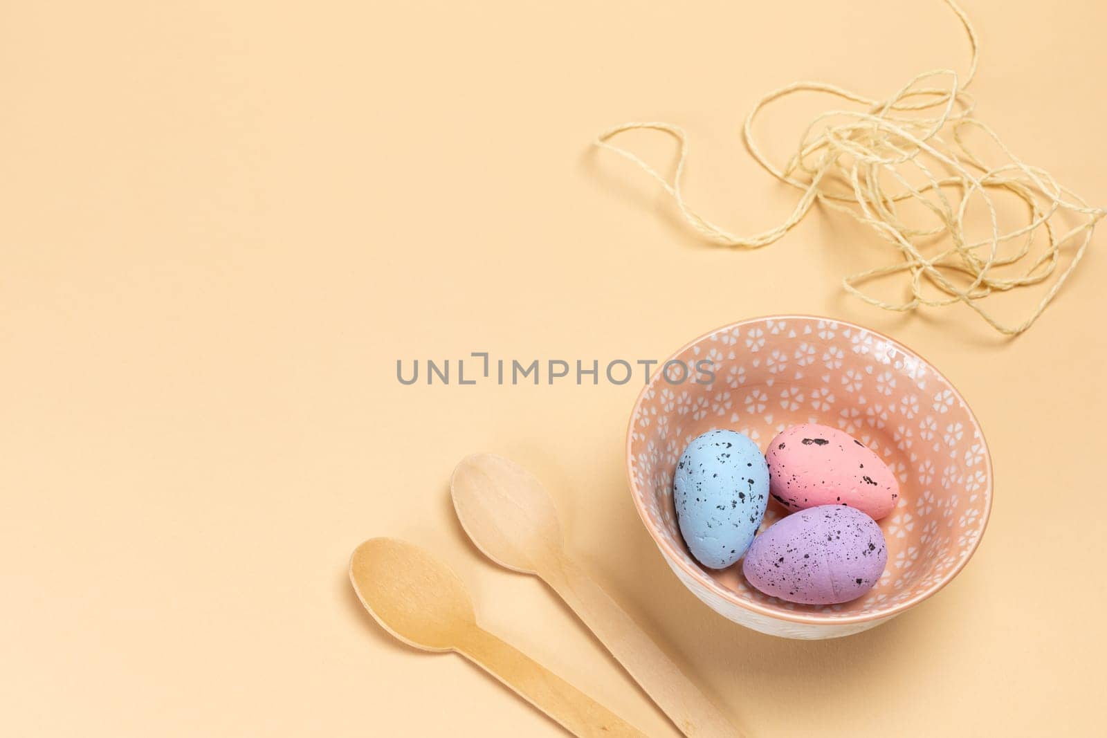 Bowl with colored Easter eggs and wooden spoons. by mvg6894