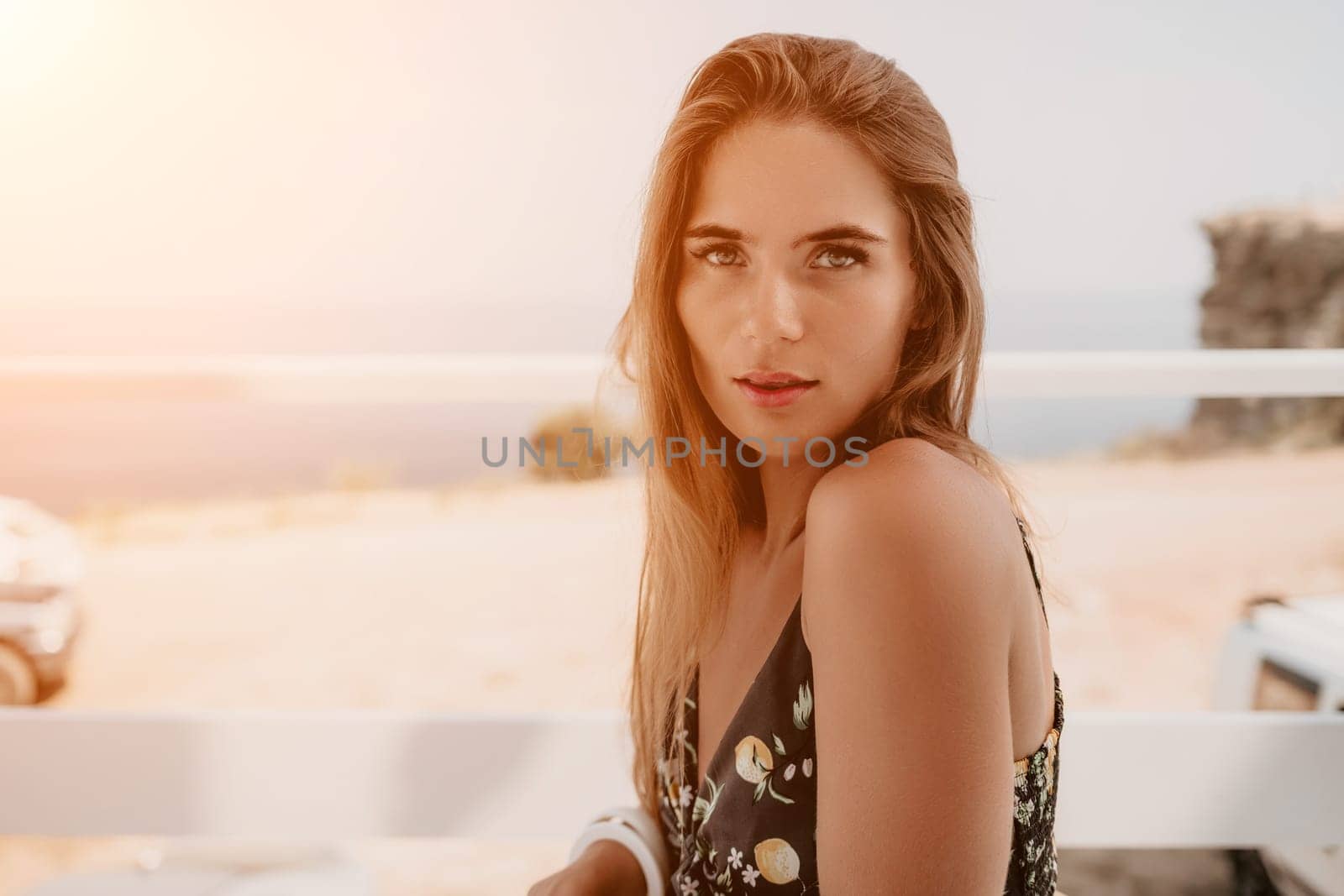 Happy woman portrait in cafe. Boho chic fashion style. Outdoor photo of young happy woman with long hair, sunny weather outdoors sitting in modern cafe