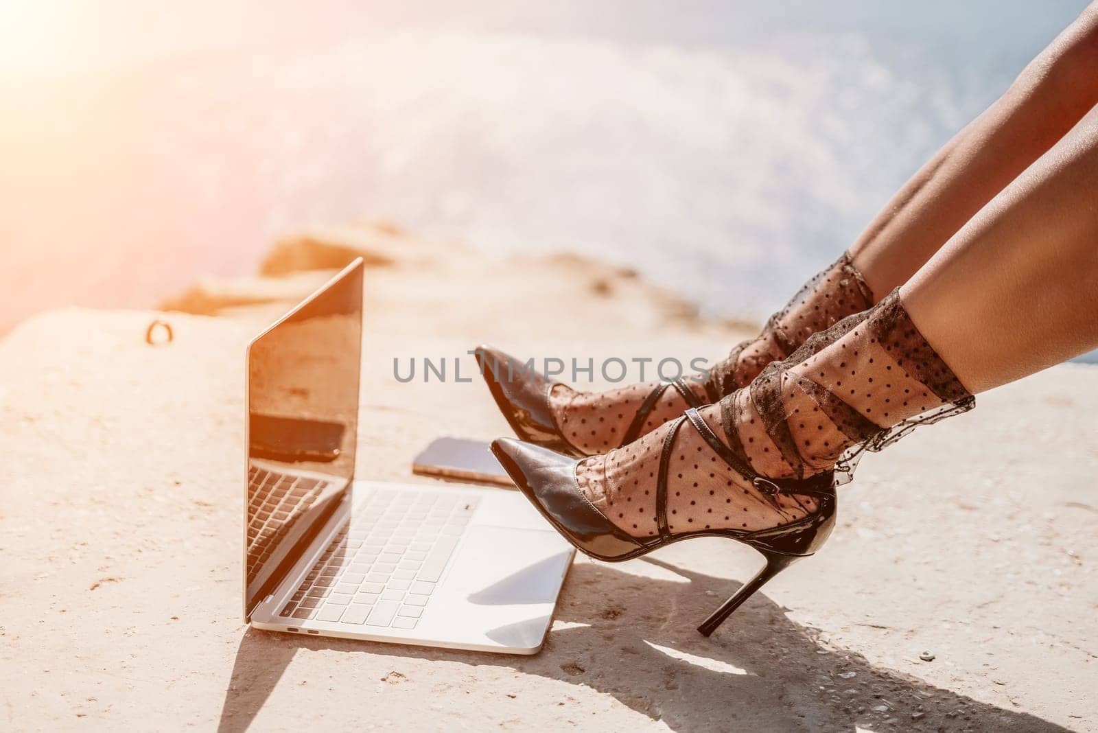 Woman sea laptop. Business woman in yellow hat freelancer with laptop working over blue sea beach. Girl relieves stress from work. Freelance, digital nomad, travel and holidays concept by panophotograph