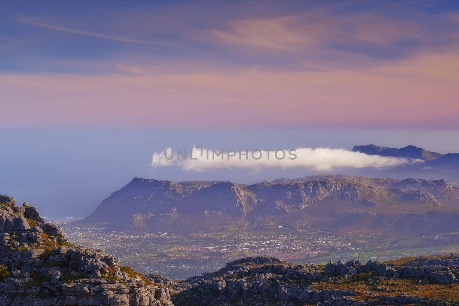 Mountains, color and natural landscape with cloudy sky, sunset and calm cliff at travel location. Nature, island and sustainable environment with earth, peace and pink tropical holiday destination by YuriArcurs