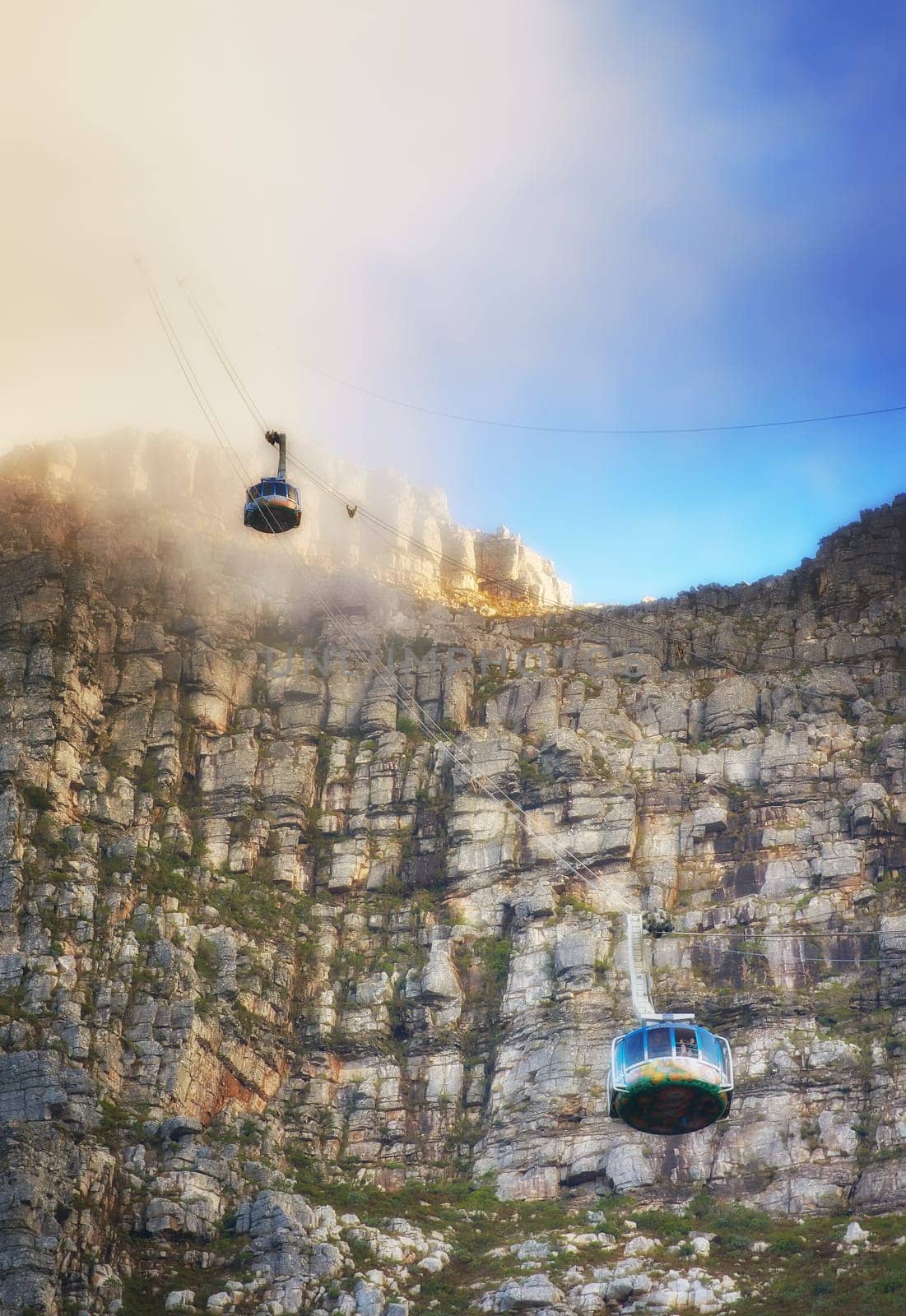 Nature, clouds and blue sky with aerial cable car on Table Mountain for outdoor adventure, travel destination and sightseeing. Low angle, national landmark and tourism for peace, calm and relax