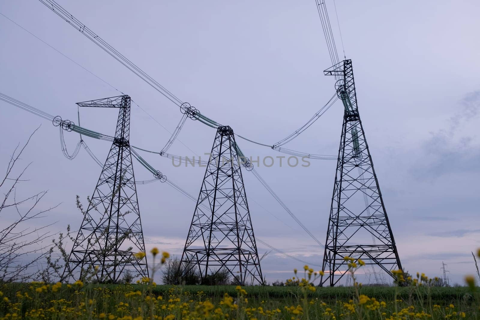 High voltage post or High voltage tower in the field. High voltage towers with sky background. A high voltage power pylons by igor010