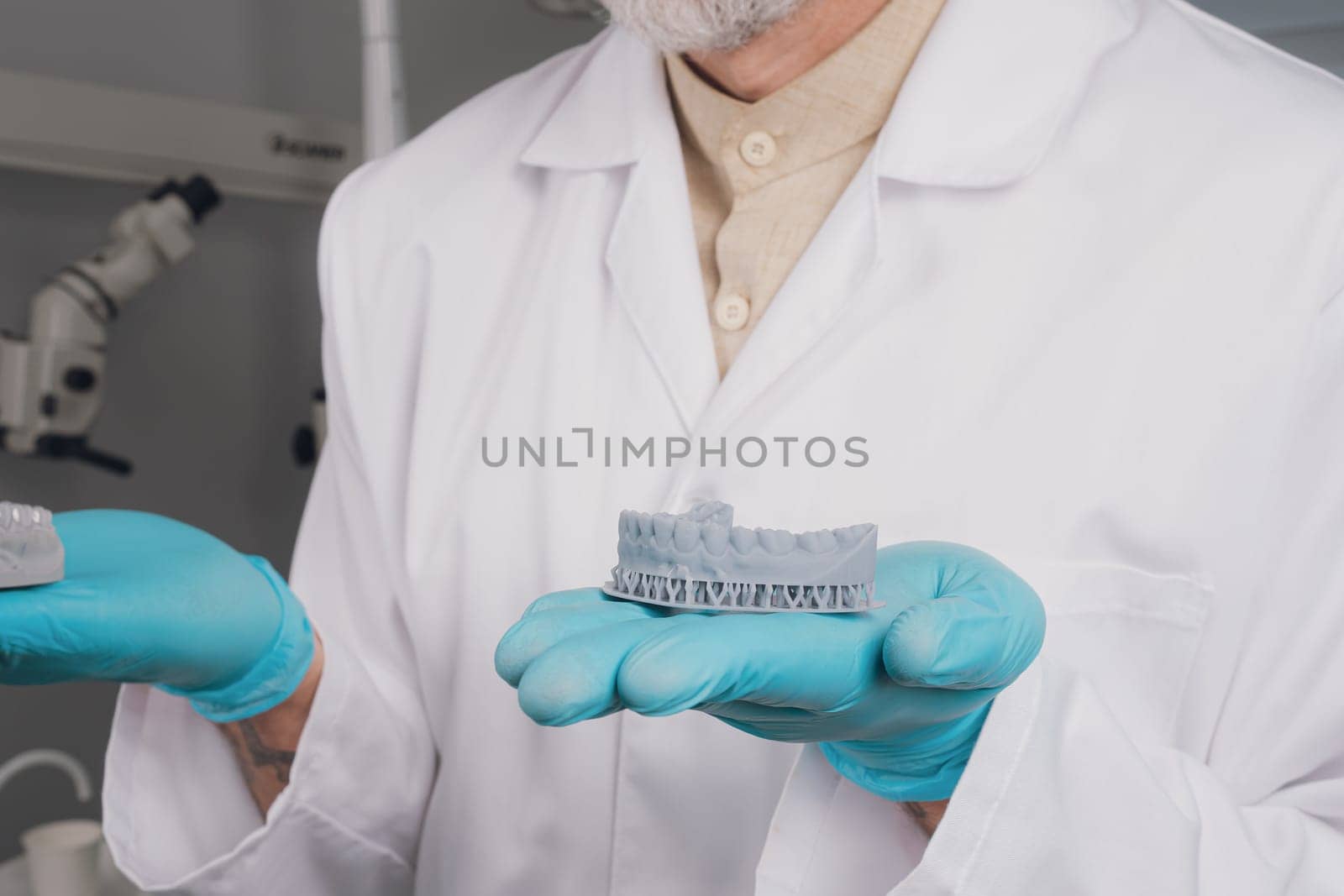 Portrait of attractive handsome dentist with haircut, white lab coat.