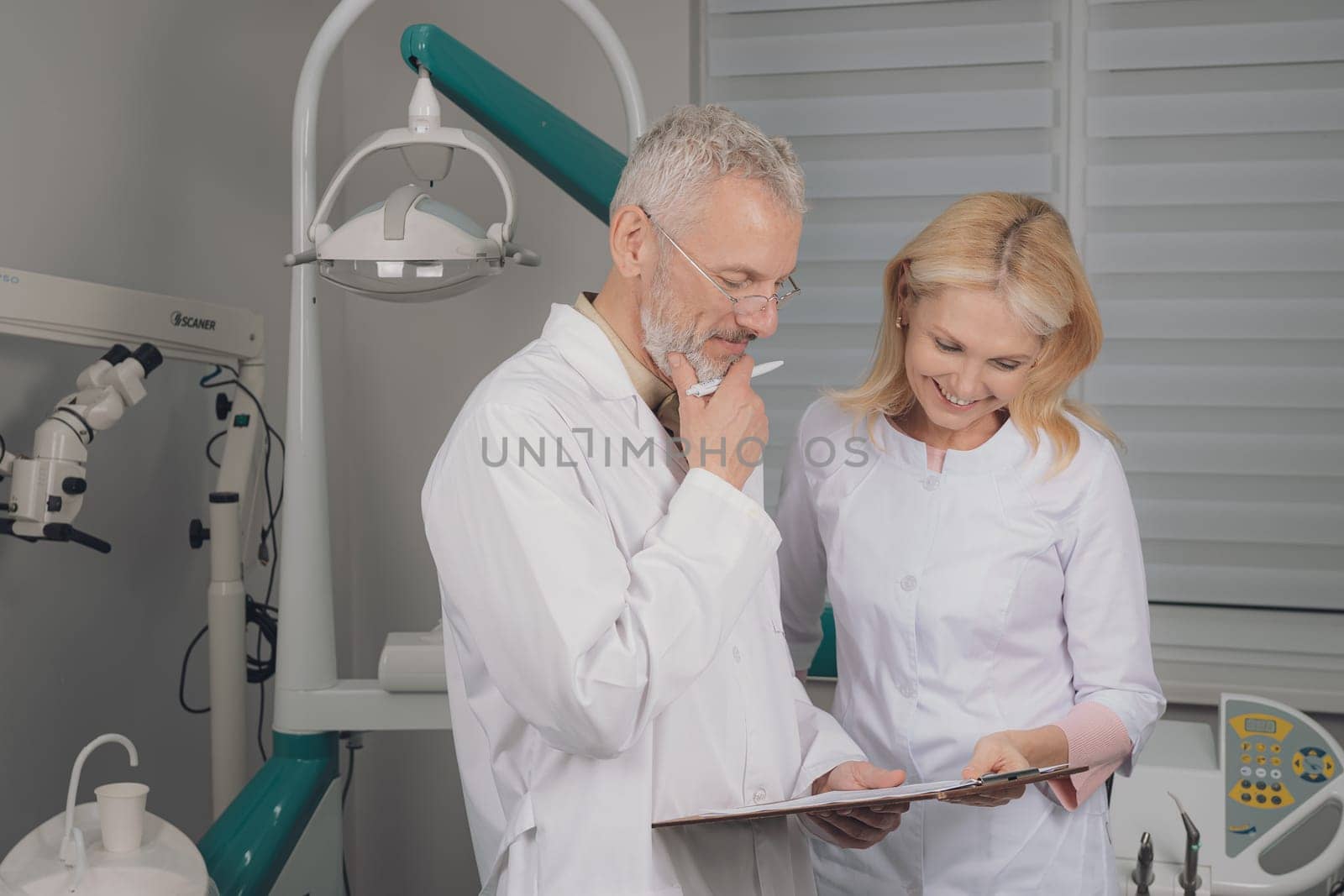 Male and female dental doctors wearing face sitting at his clinic. High quality photo
