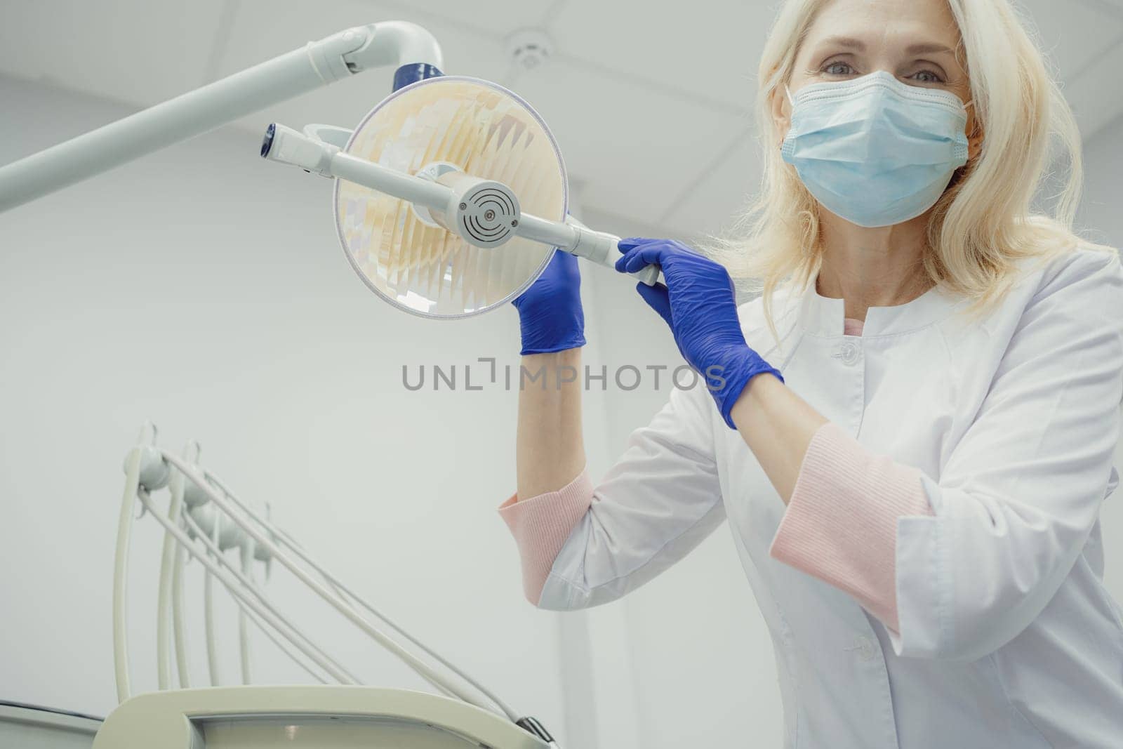 Woman working in dental clinic and doctor in background. High quality photo