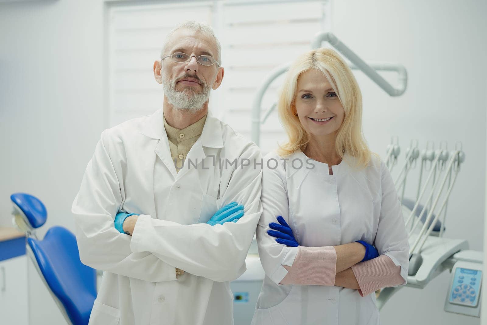 Male and female dental doctors wearing face sitting at his clinic. High quality photo