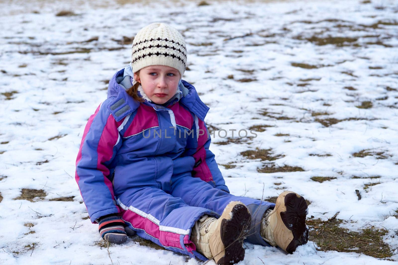 Upset offended crying child in overalls sitting on the snow by jovani68