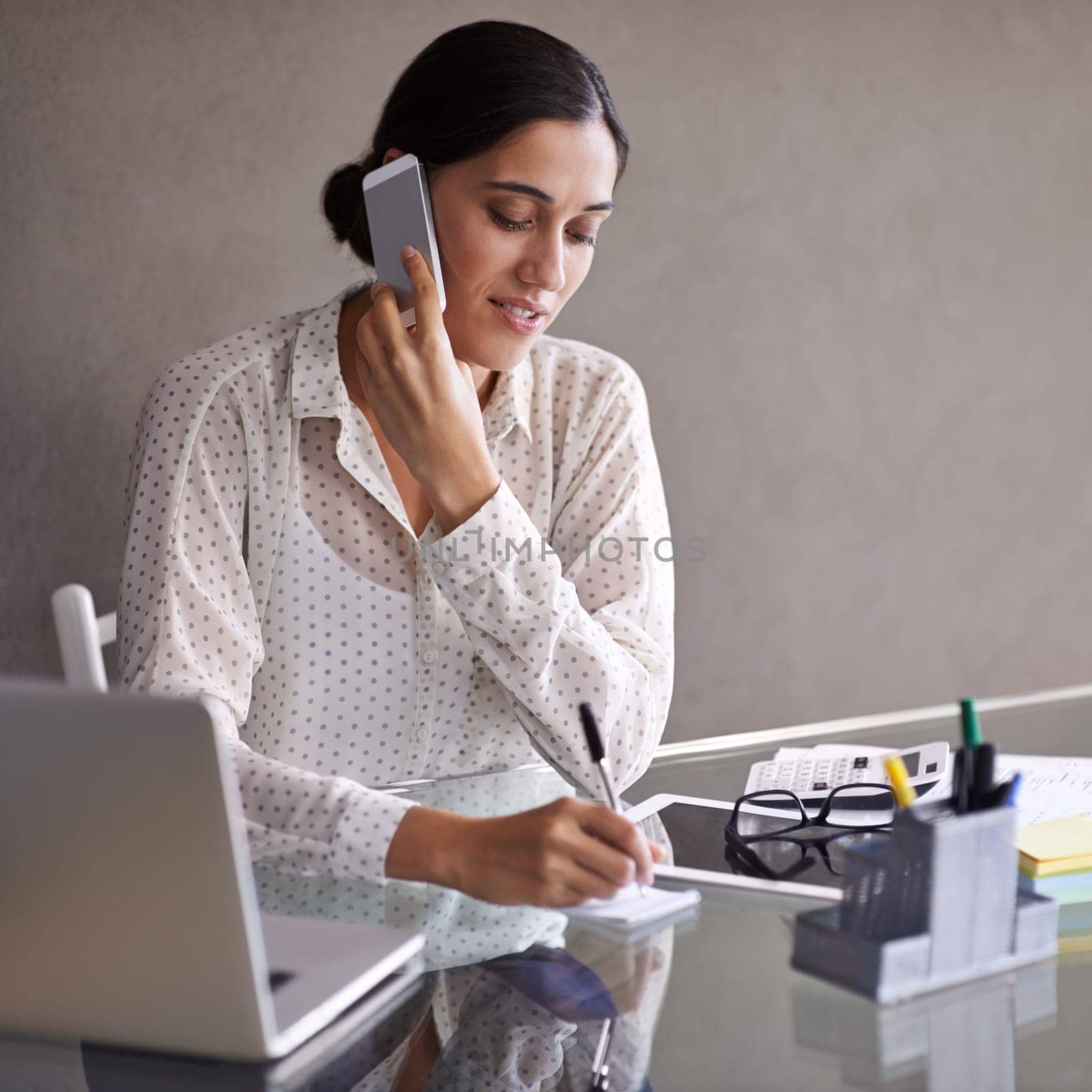 Businesswoman, phone call and office with laptop, desk and cellphone in meeting. Technology, computer and writing notes for financial advisor, manager and communication with client for budget by YuriArcurs