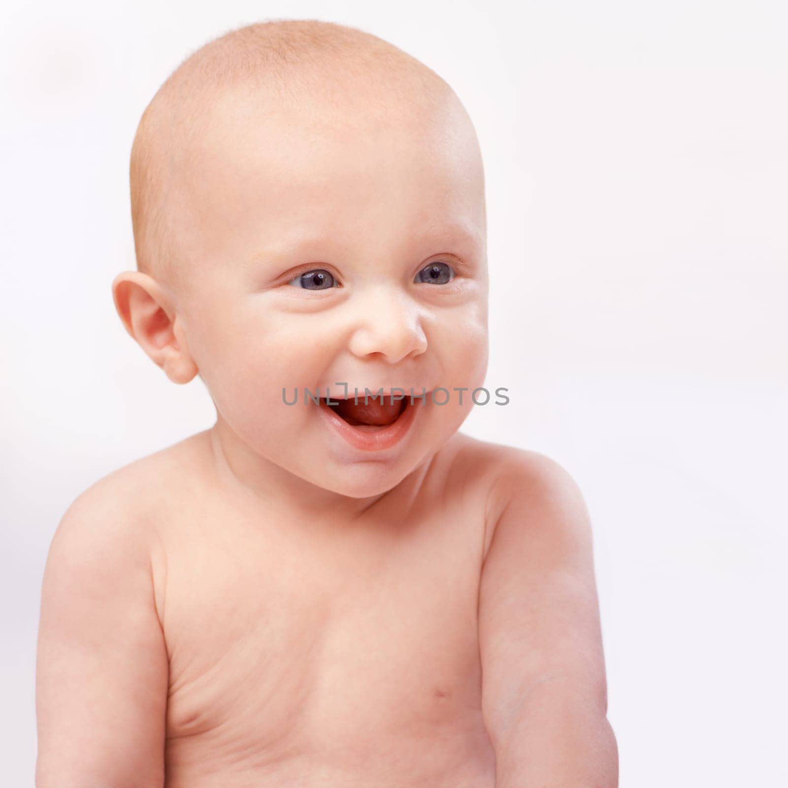 Young, happy and face of baby on a white background for child development, laugh and growth. Curious, facial expression and closeup of isolated newborn for childhood, wellness and adorable in studio by YuriArcurs