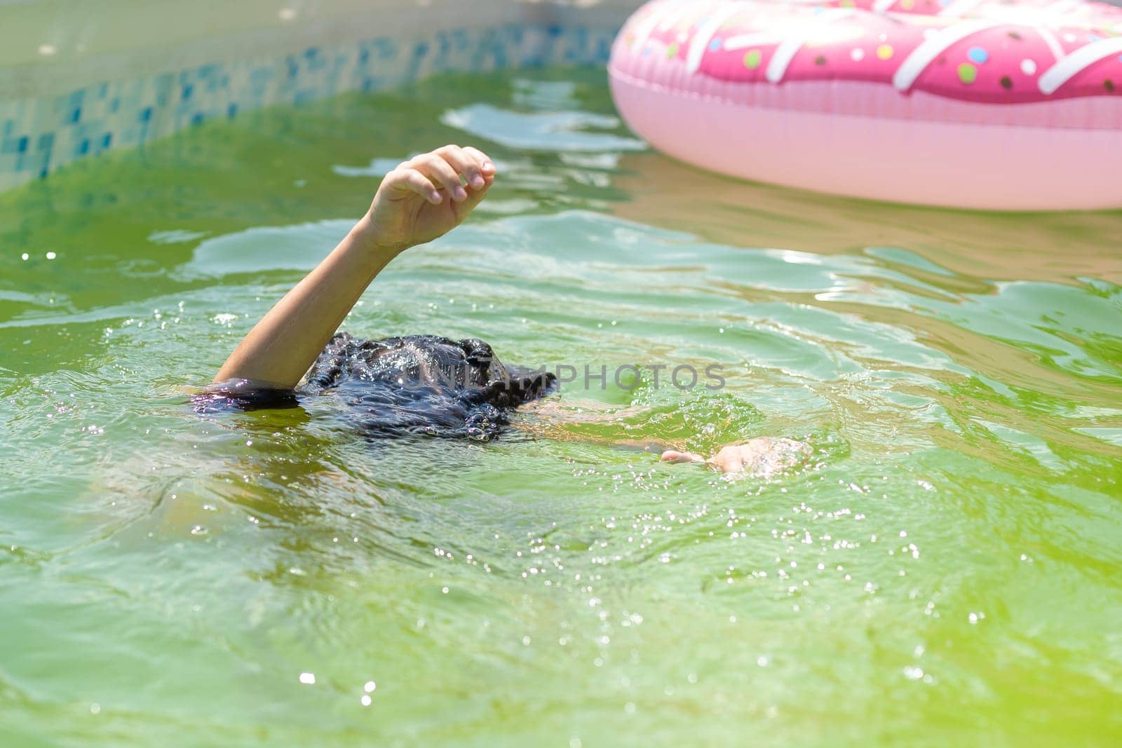 little girl in the green water of very dirty pool.