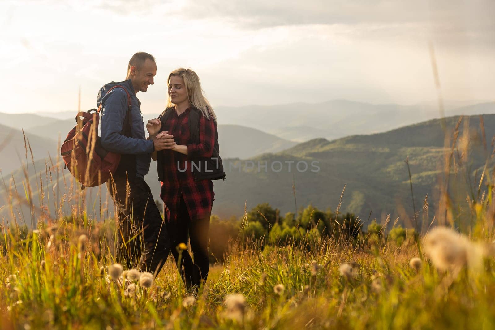 beautiful young couple enjoying nature at mountain by Andelov13