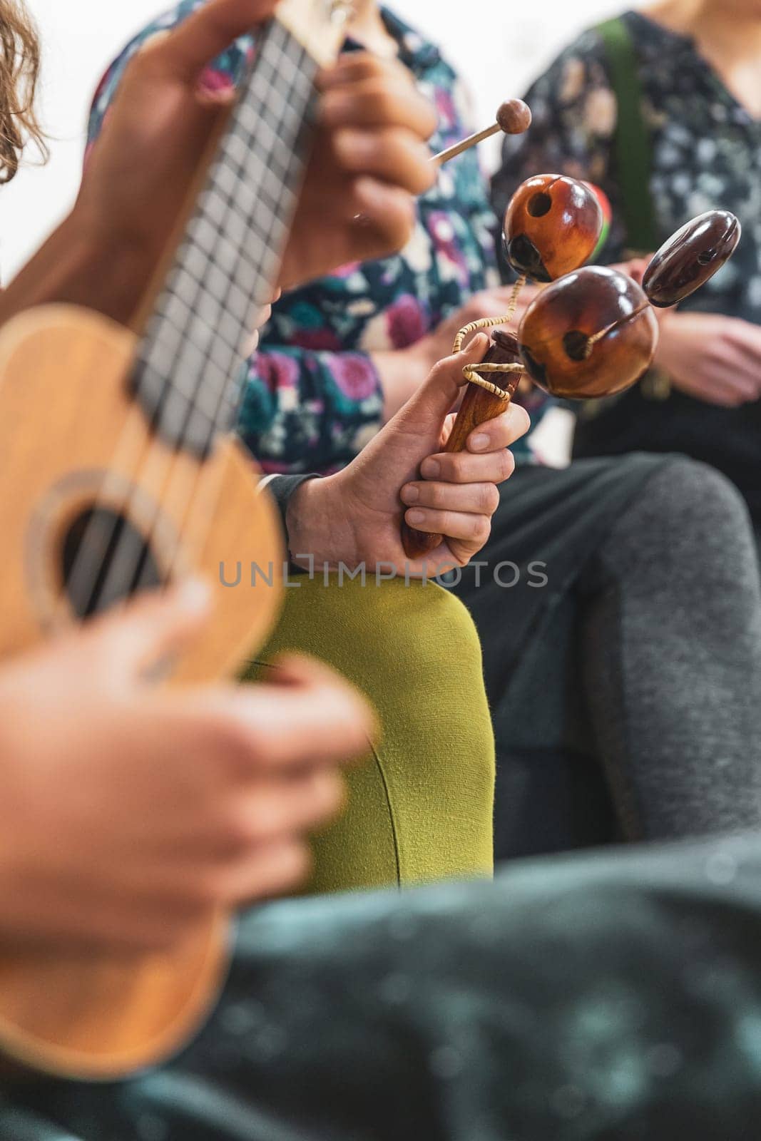 Group of people playing on the different kinds of musical instruments during music therapy
