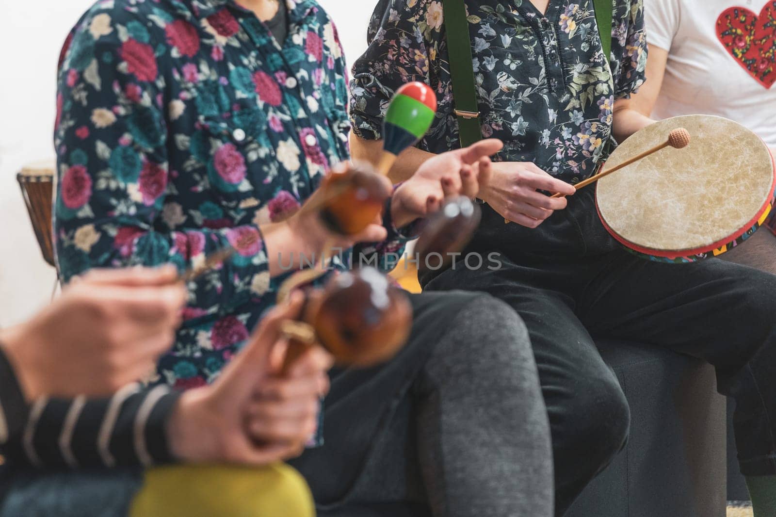 Group of people playing on different kinds of musical instruments during music therapy by Kadula