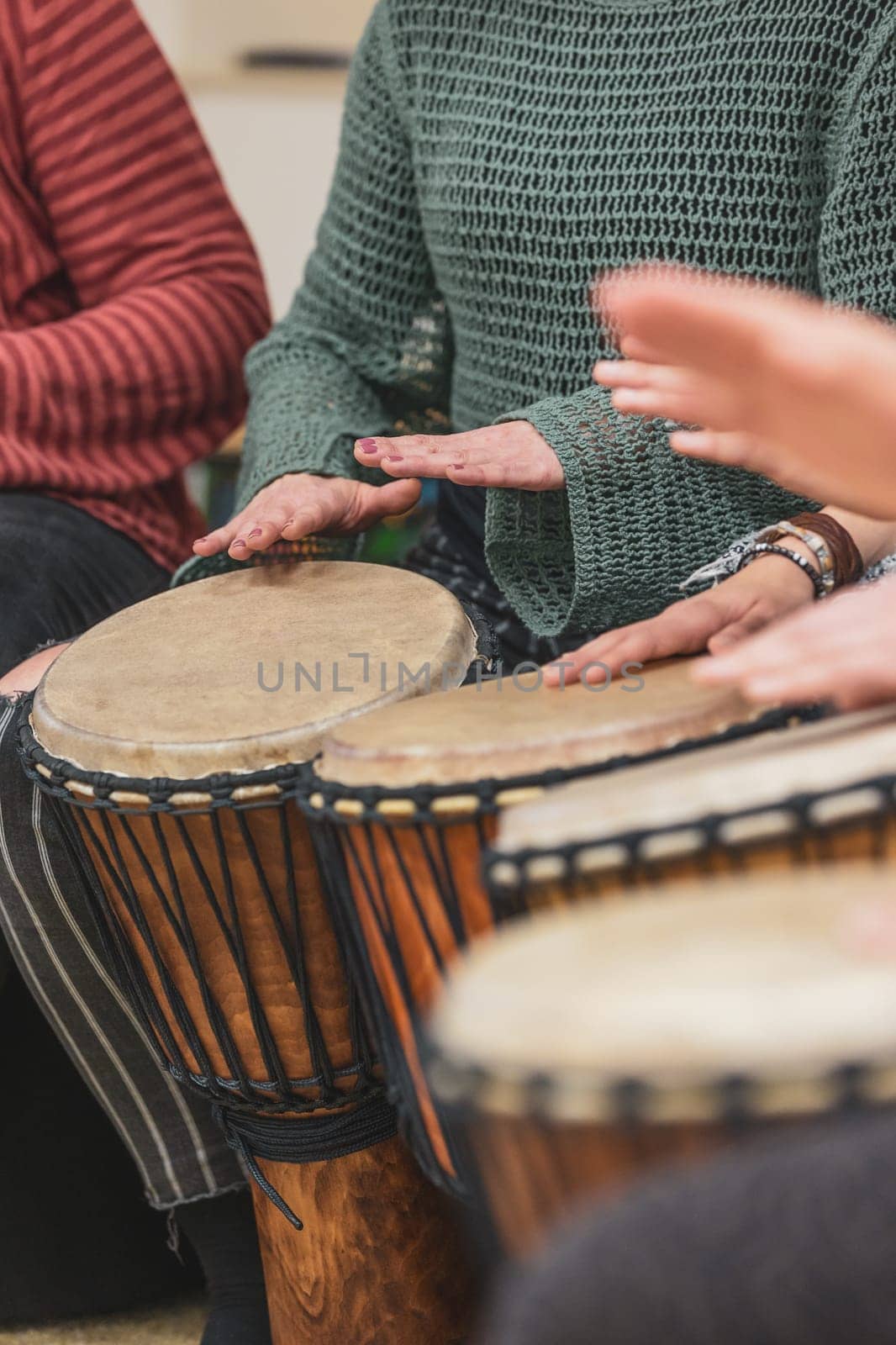 Group of people playing drums during music therapy lessons, jembe drum, drumming concept