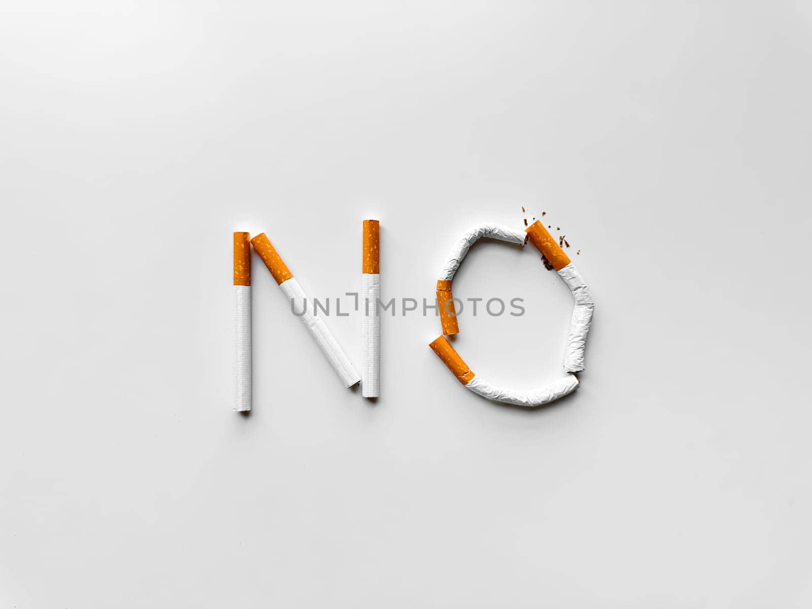 Word 'NO' made from broken cigarettes on white background, symbolizing smoking cessation and anti tobacco message. No tobacco day. by Lunnica