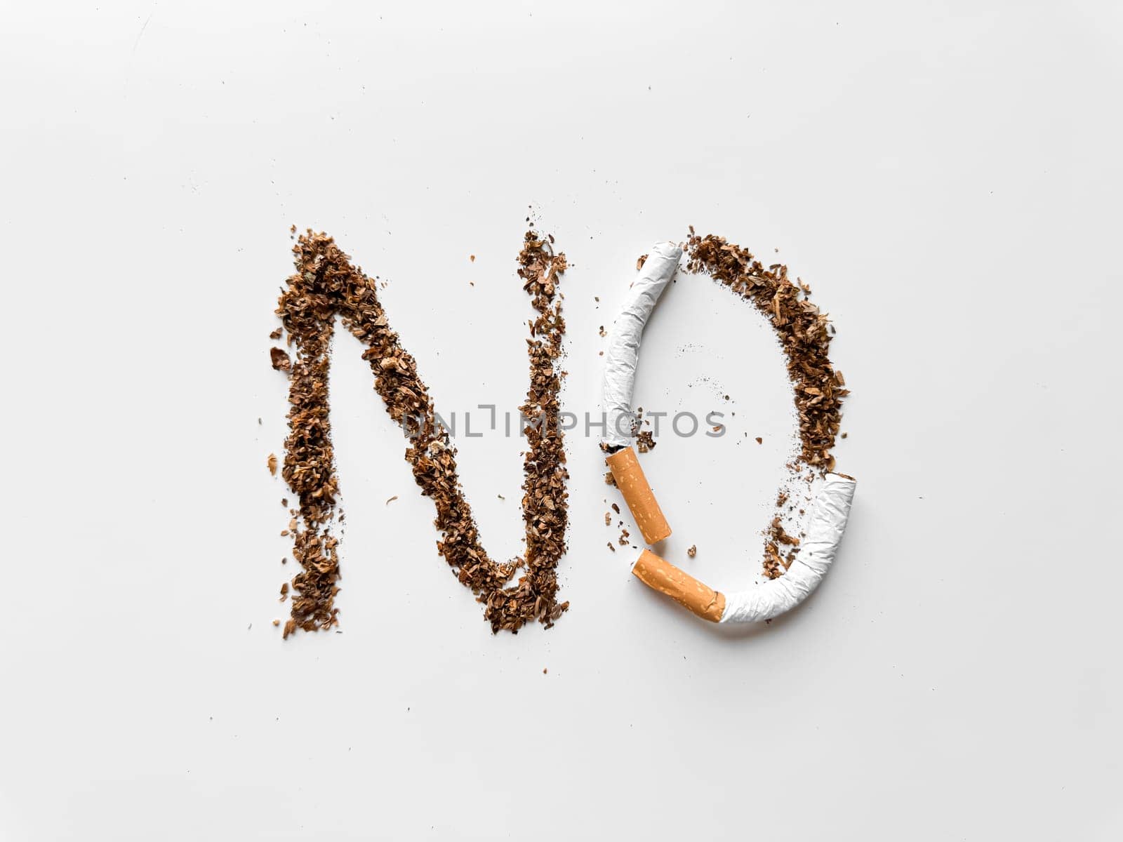 Word 'NO' created with tobacco and broken cigarette on white background for anti smoking and health concept. No tobacco day. High quality photo
